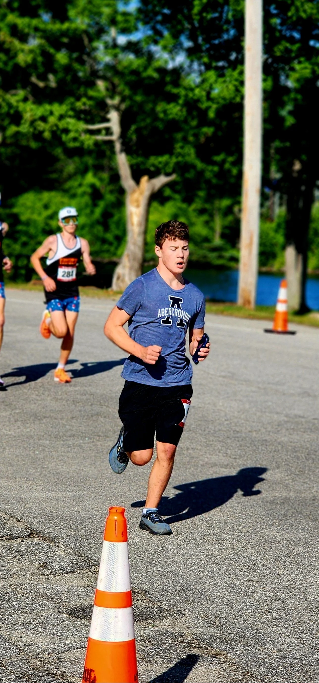 A man wearing a blue t-shirt and black shorts running