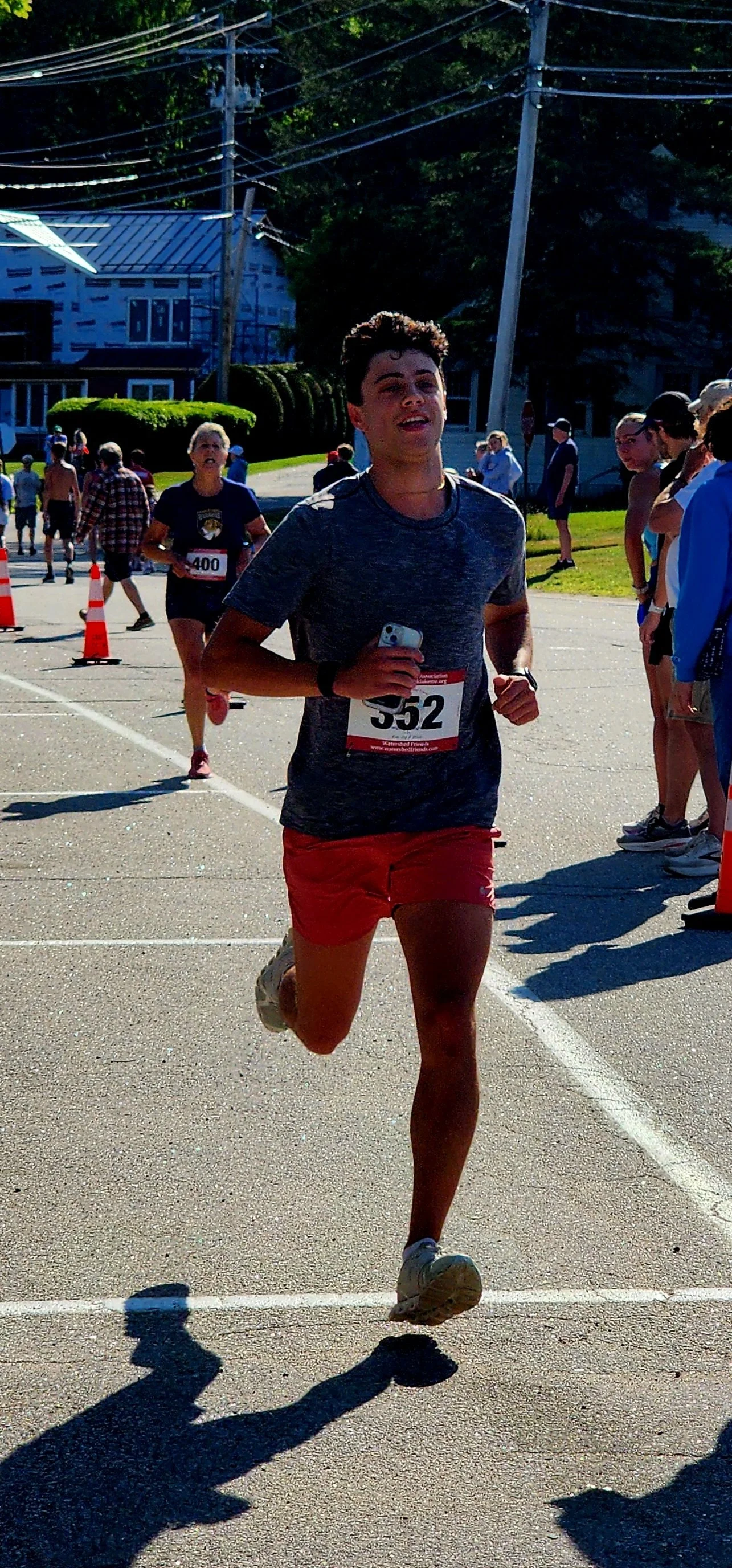 A man wearing a grey t-shirt and red shorts running