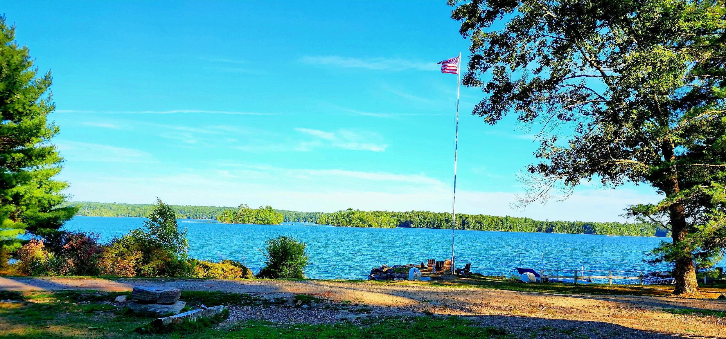 A view out over a lake with a flagpole in the middle