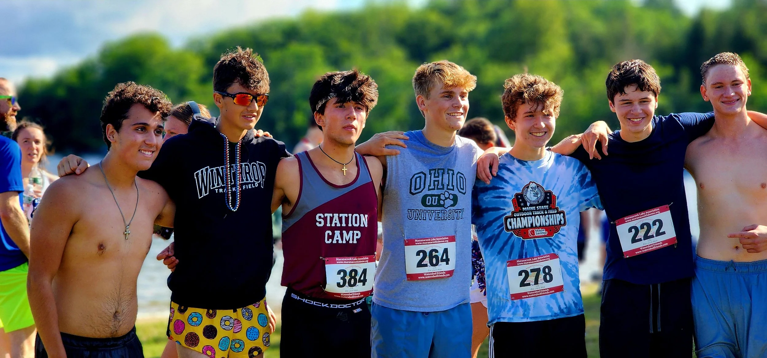 A group of seven people lined up smiling at the camera