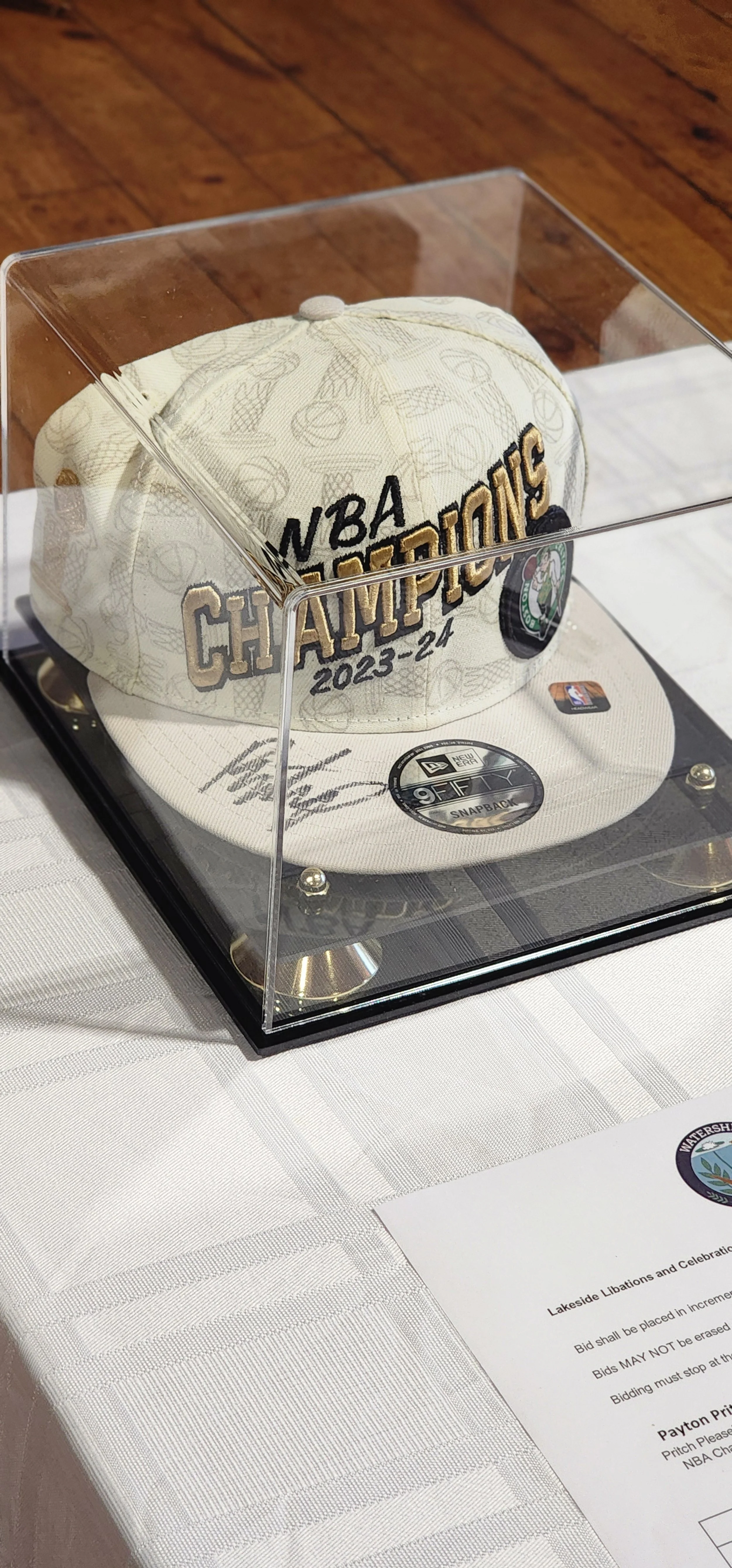 A signed Boston Celtics NBA champions hat in a glass case