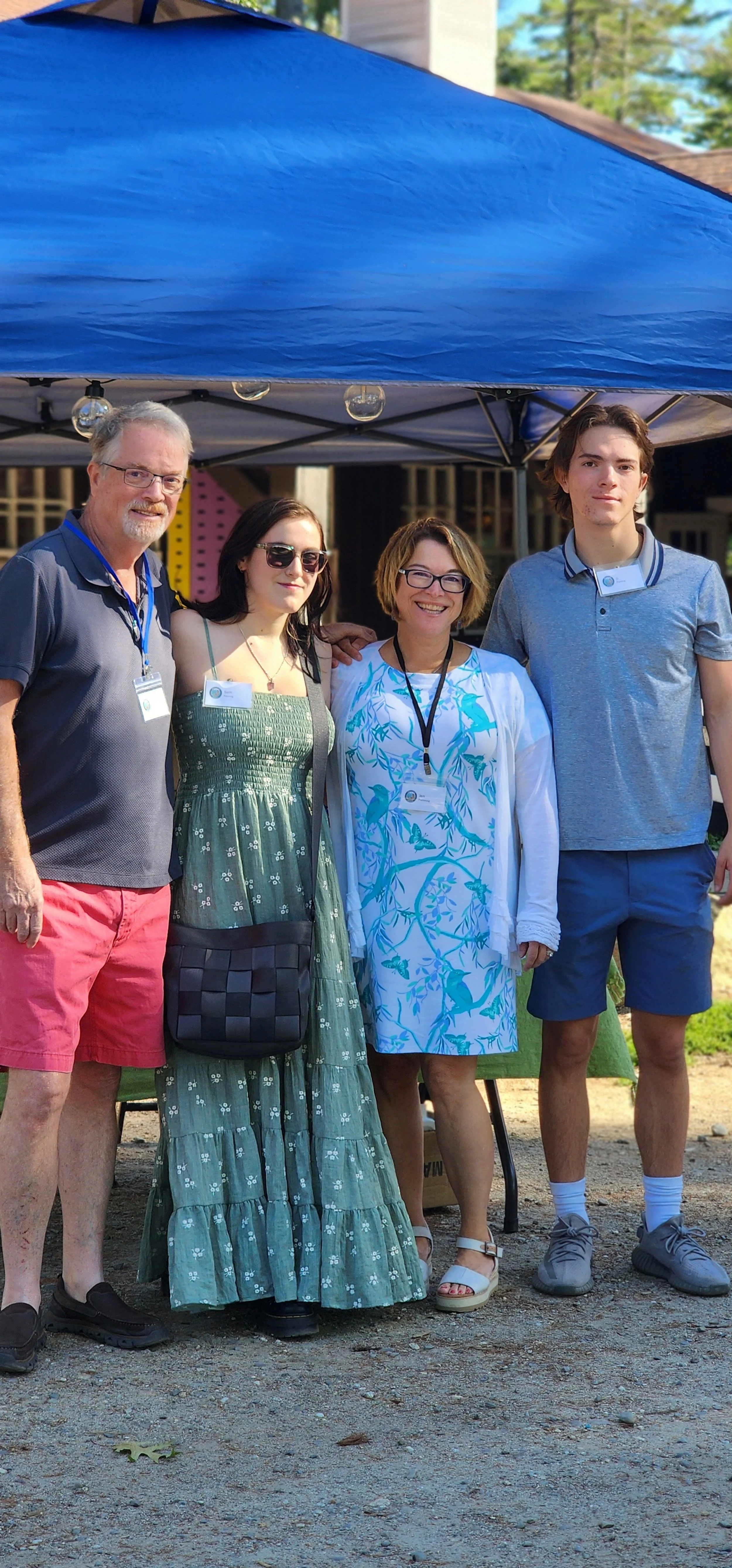 A group of four people standing under a canopy