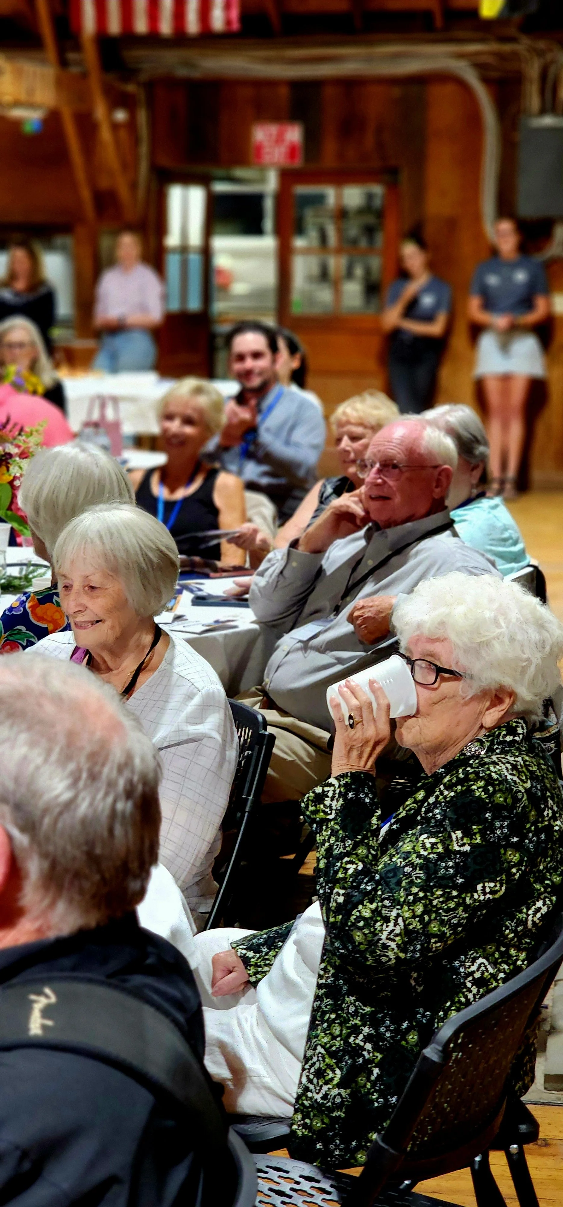 People sitting at tables watching something off camera