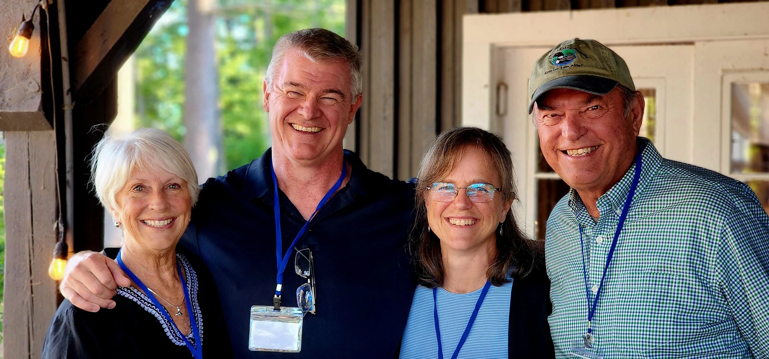 Four people, two men and two women, smiling at the camera