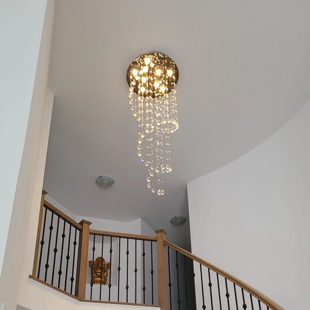 A ceiling chandelier with hanging crystal beads in a modern home interior.