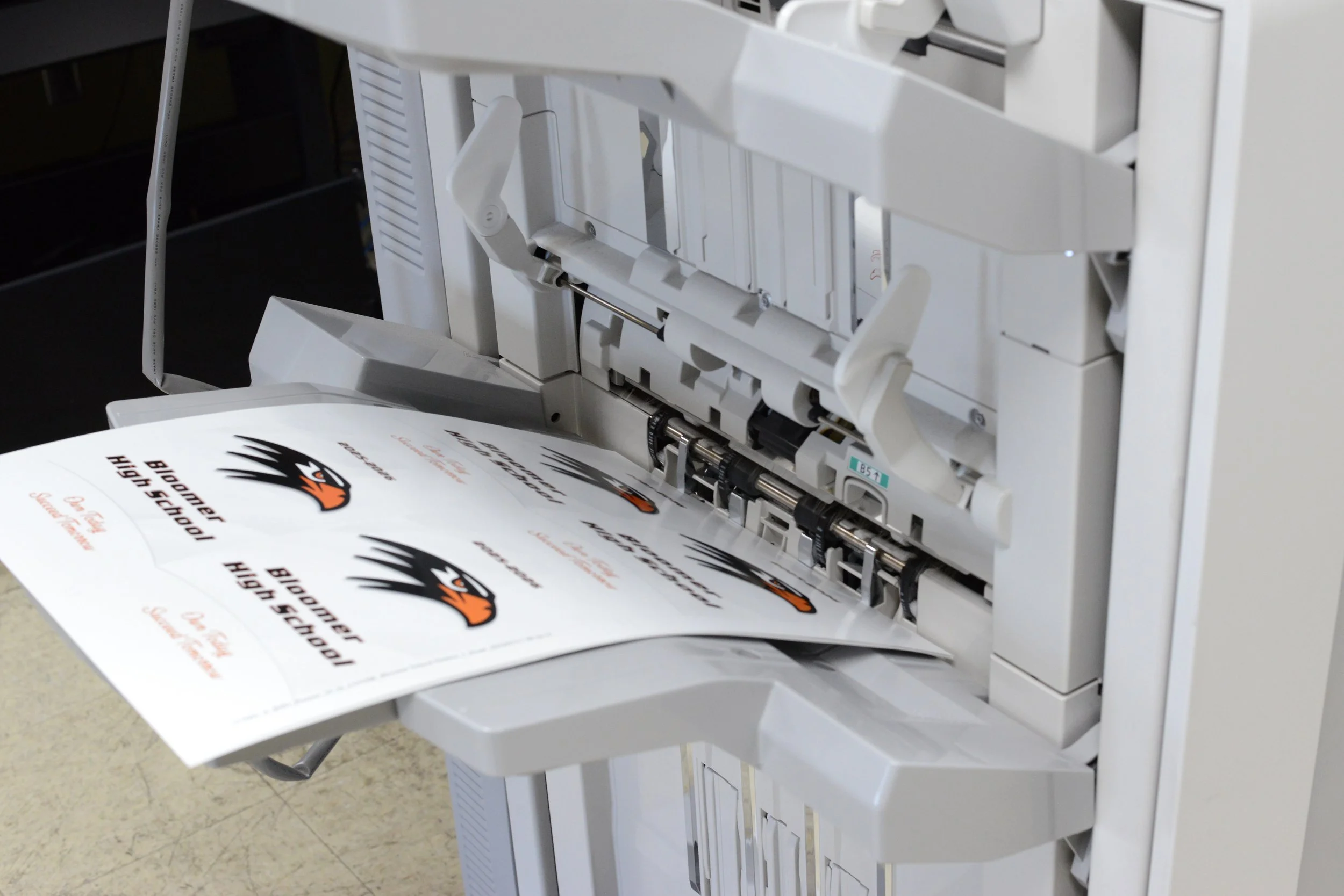 Printed sticker sheets running through a finishing machine