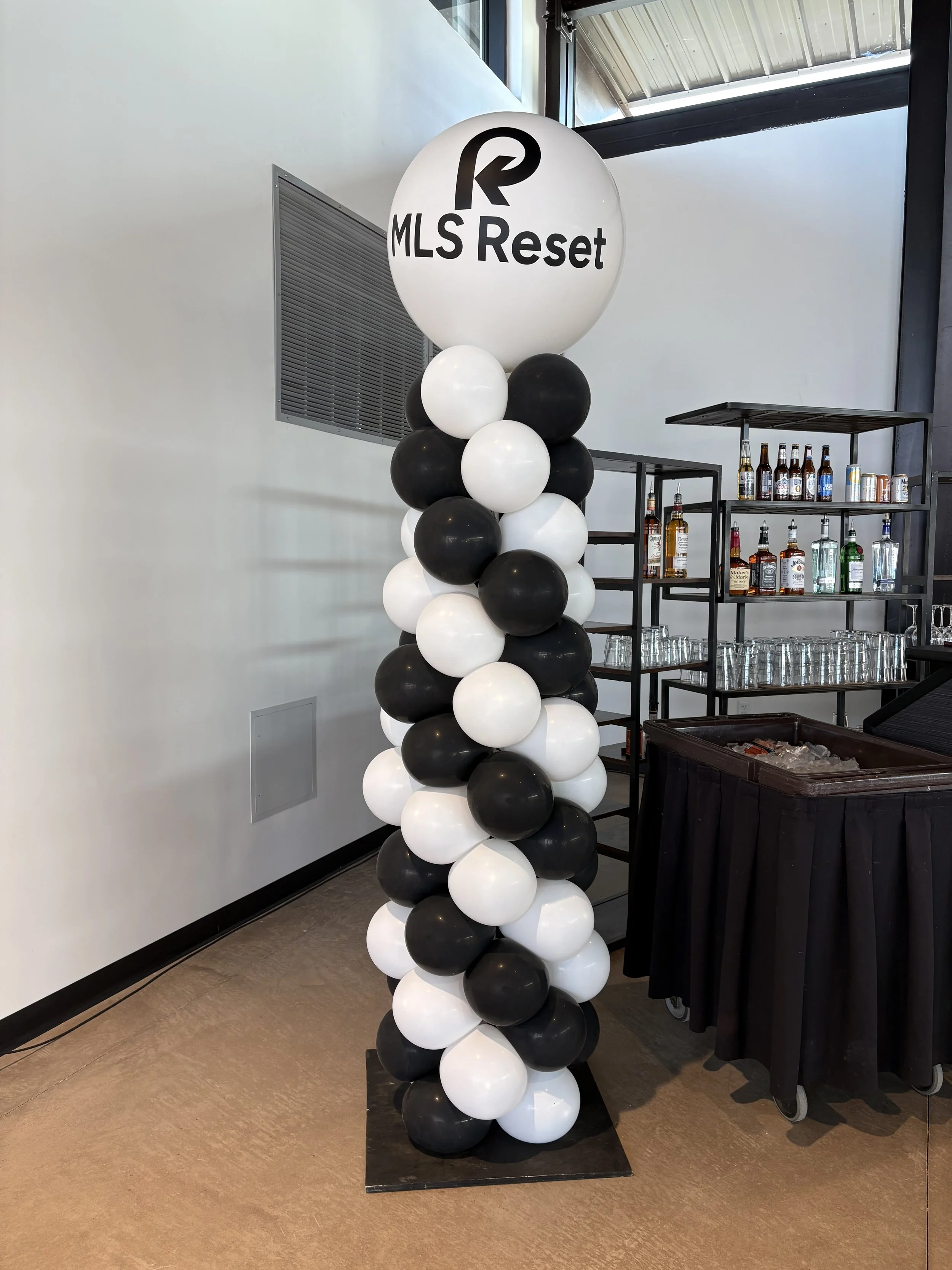 Balloon column with black and white balloons and a large balloon at the top reading 'MLS Reset' with the MLS logo.