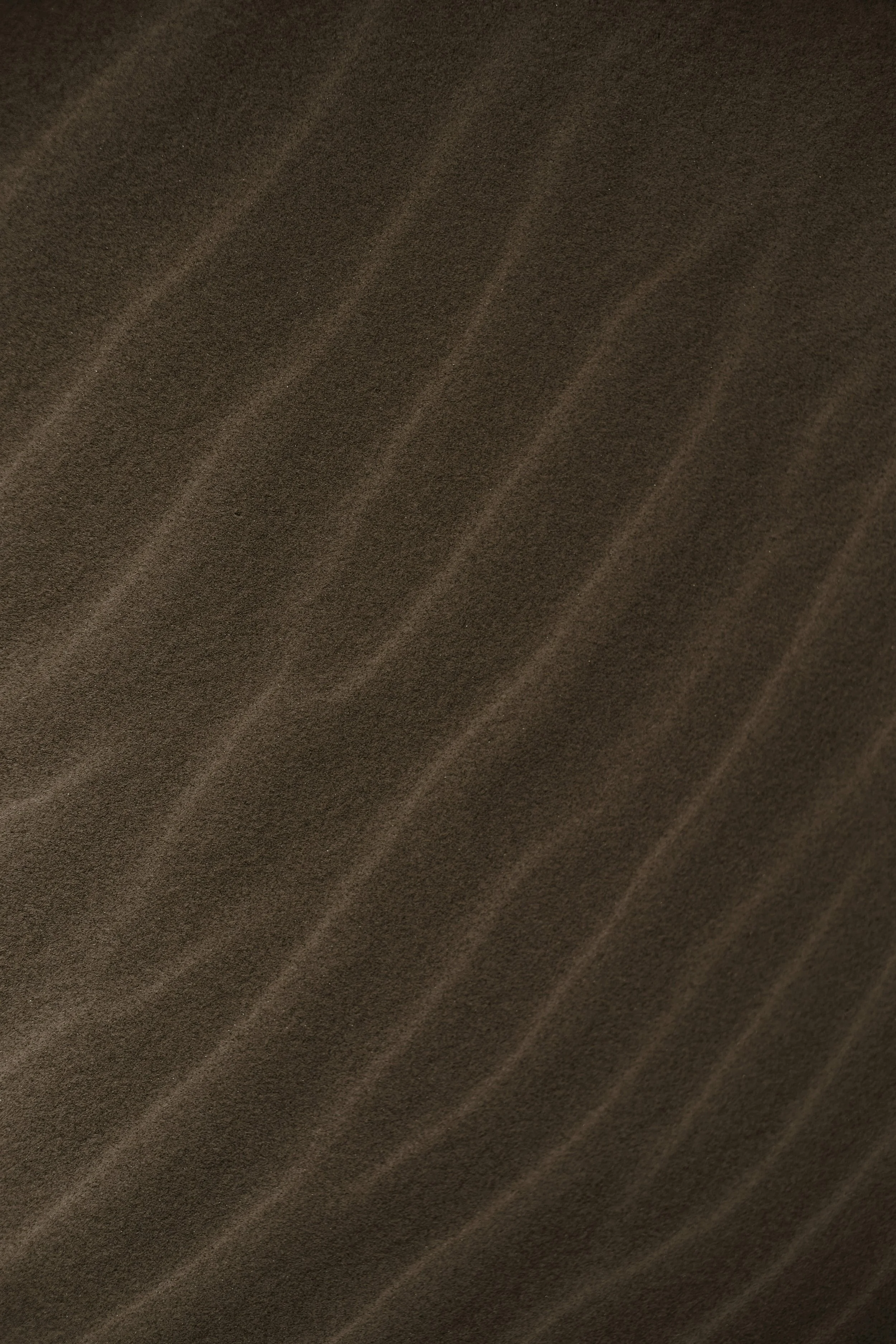 Close-up of a brown textured surface with diagonal lines resembling fabric or material.