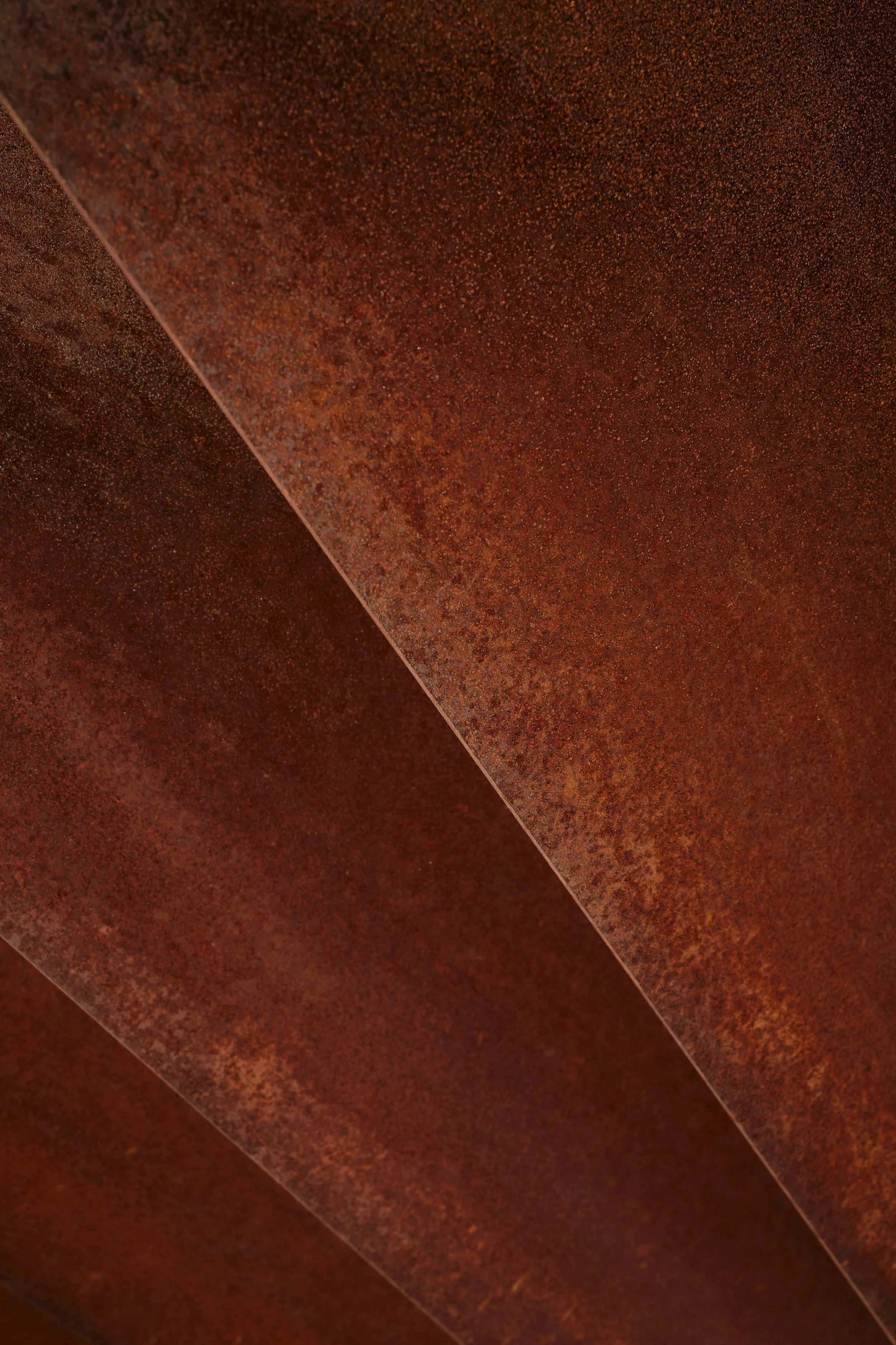 Close-up of rusted metal sheets with a reddish-brown patina.