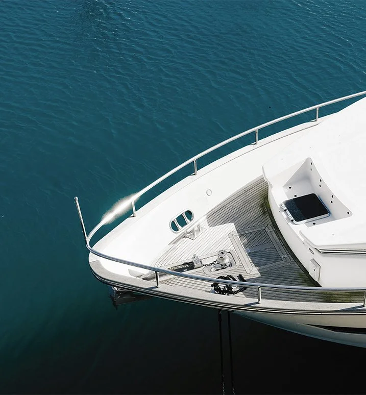White yacht viewed from above, surrounded by deep blue ocean water.