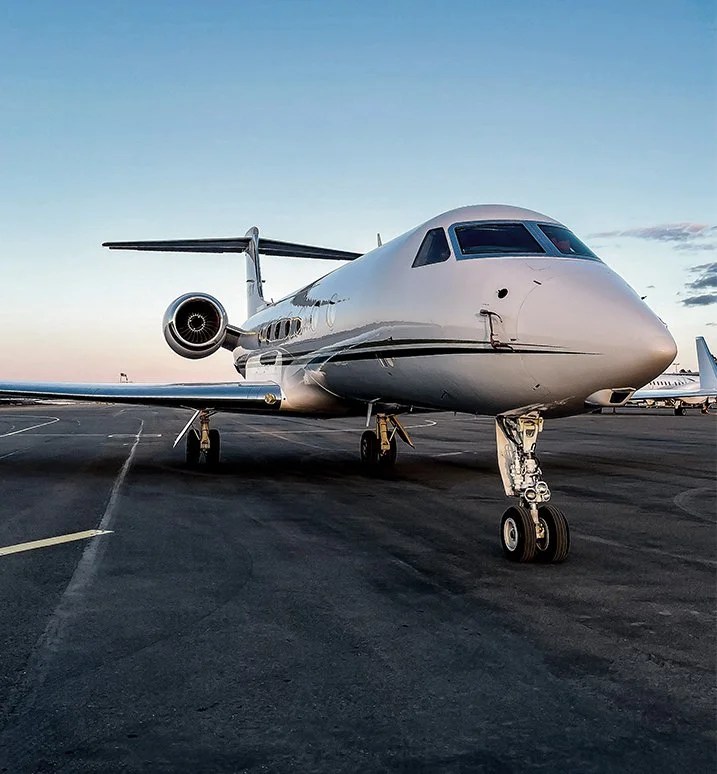 Private jet parked on an airport runway.