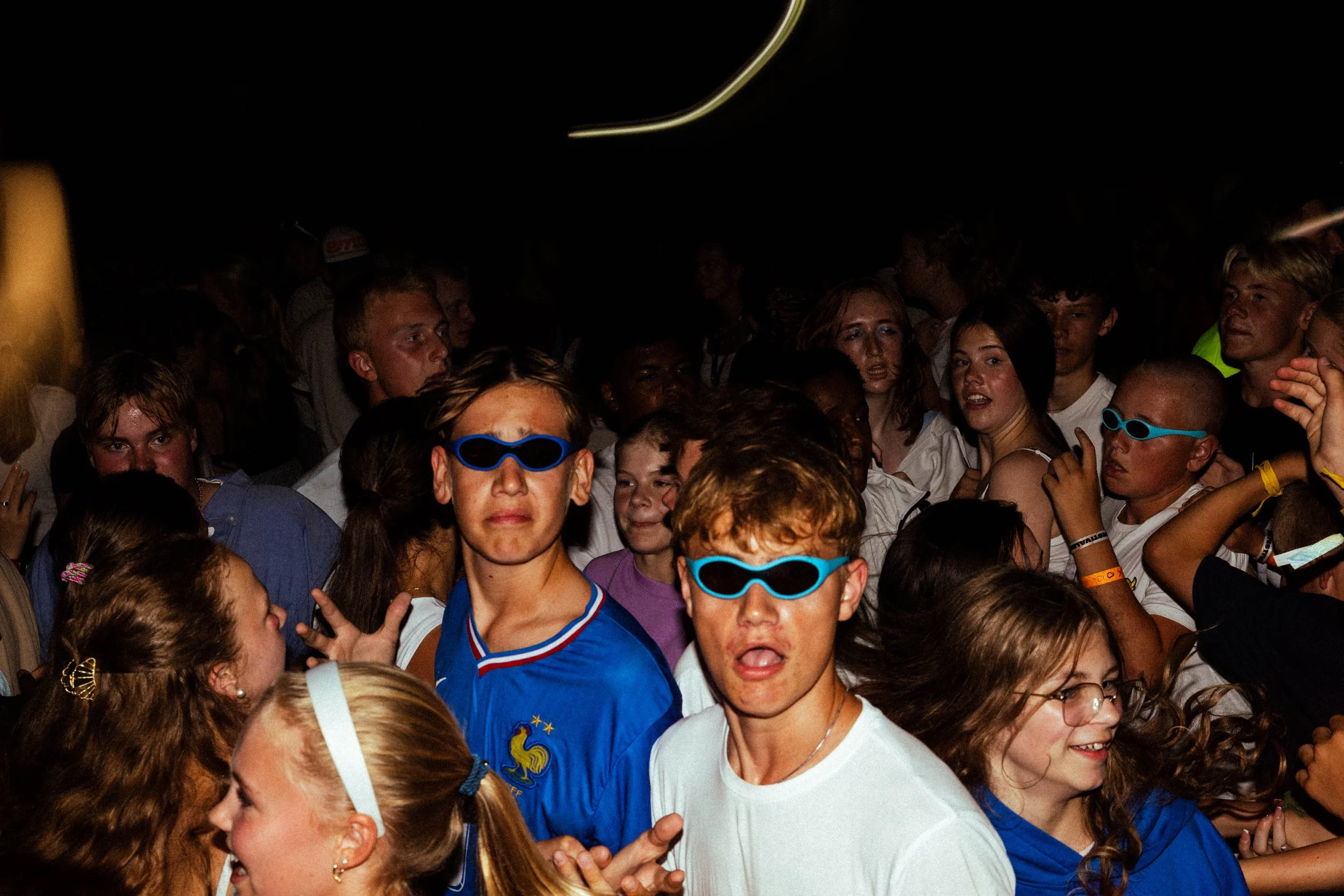 En gjeng med deltakere hopper og danser med ironiske og gøye briller