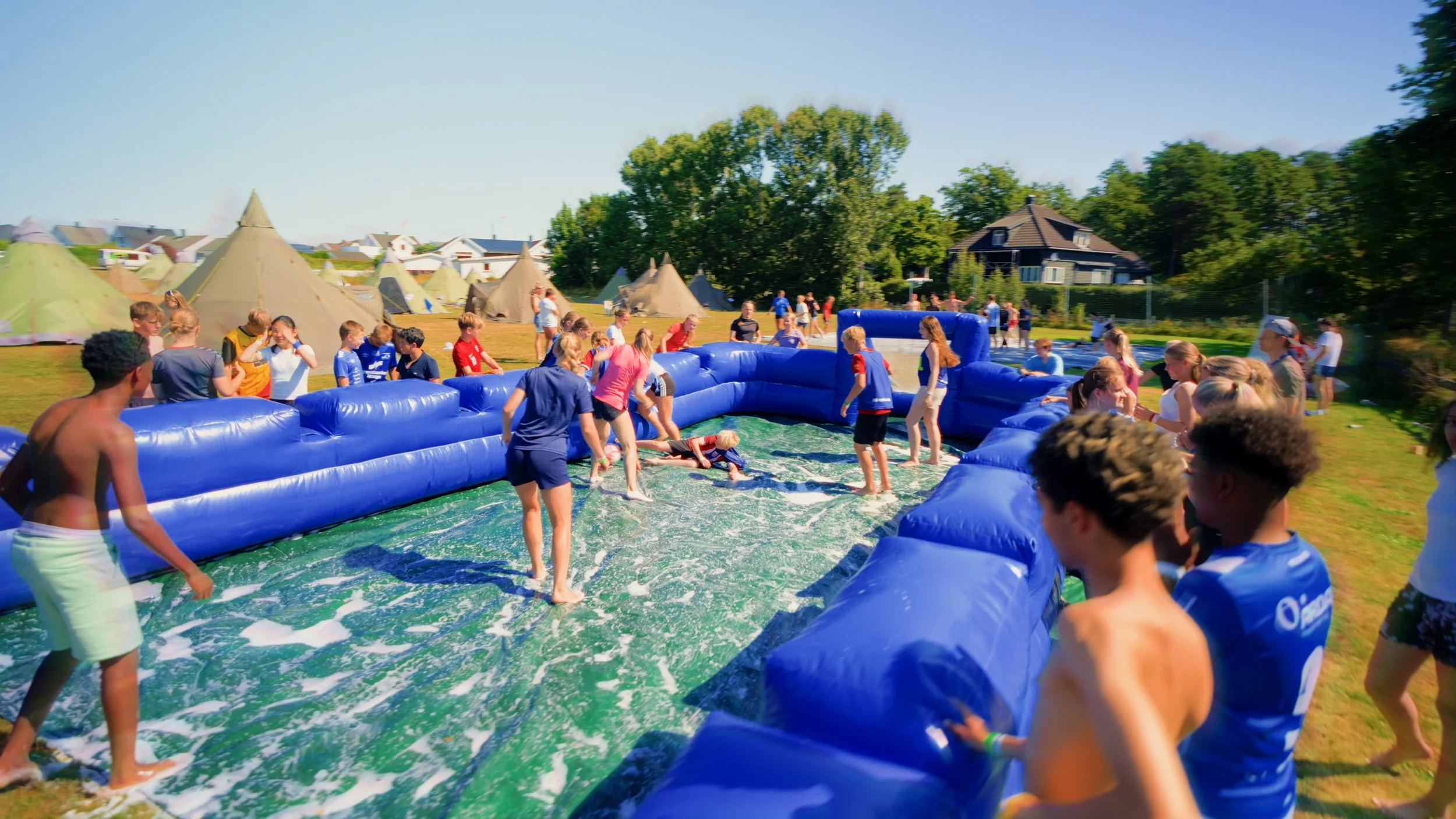 En runde med såpefotball på leirområdet. Samtlige står rundt og heier.