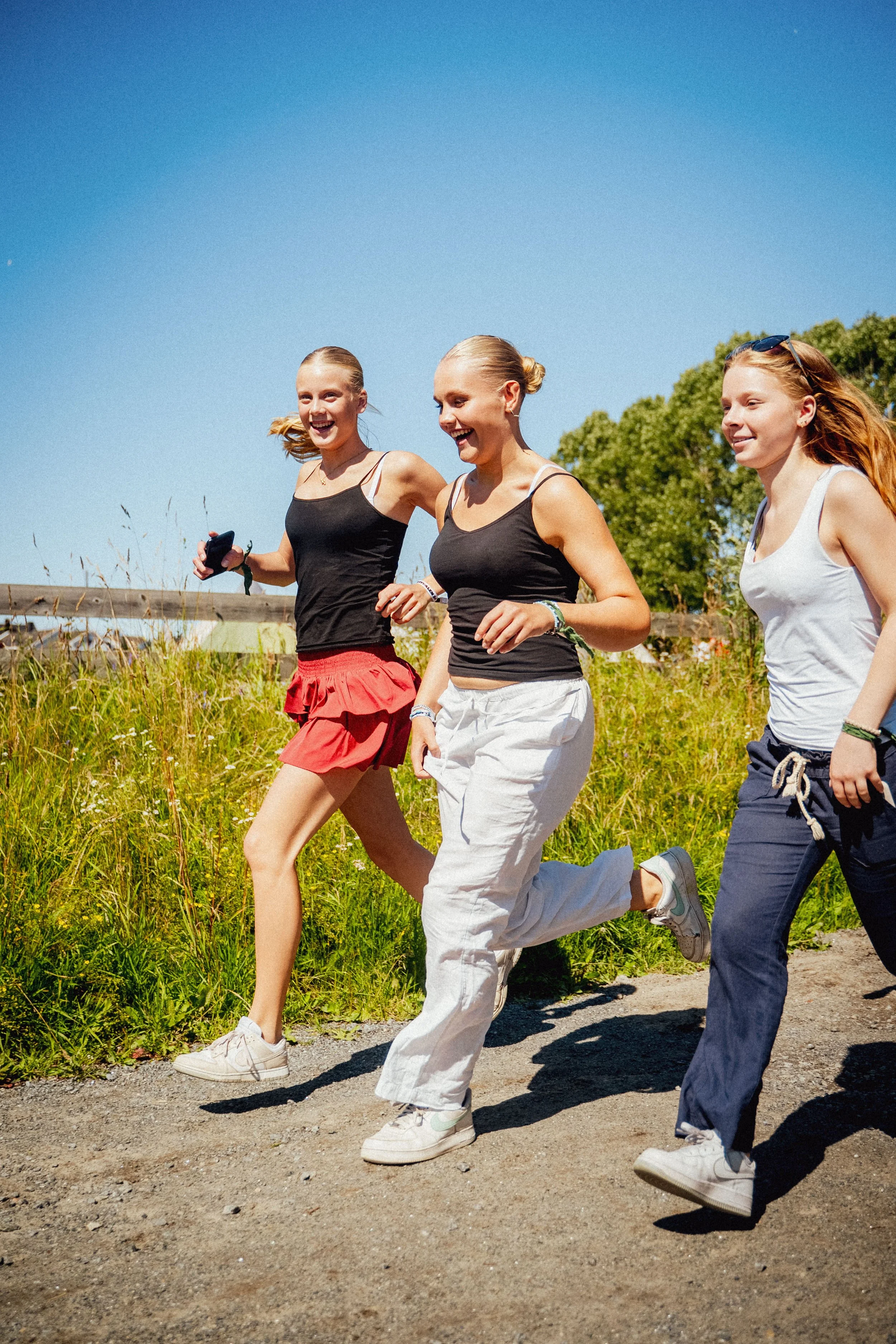 En gjeng deltakere løper og smiler i finværet