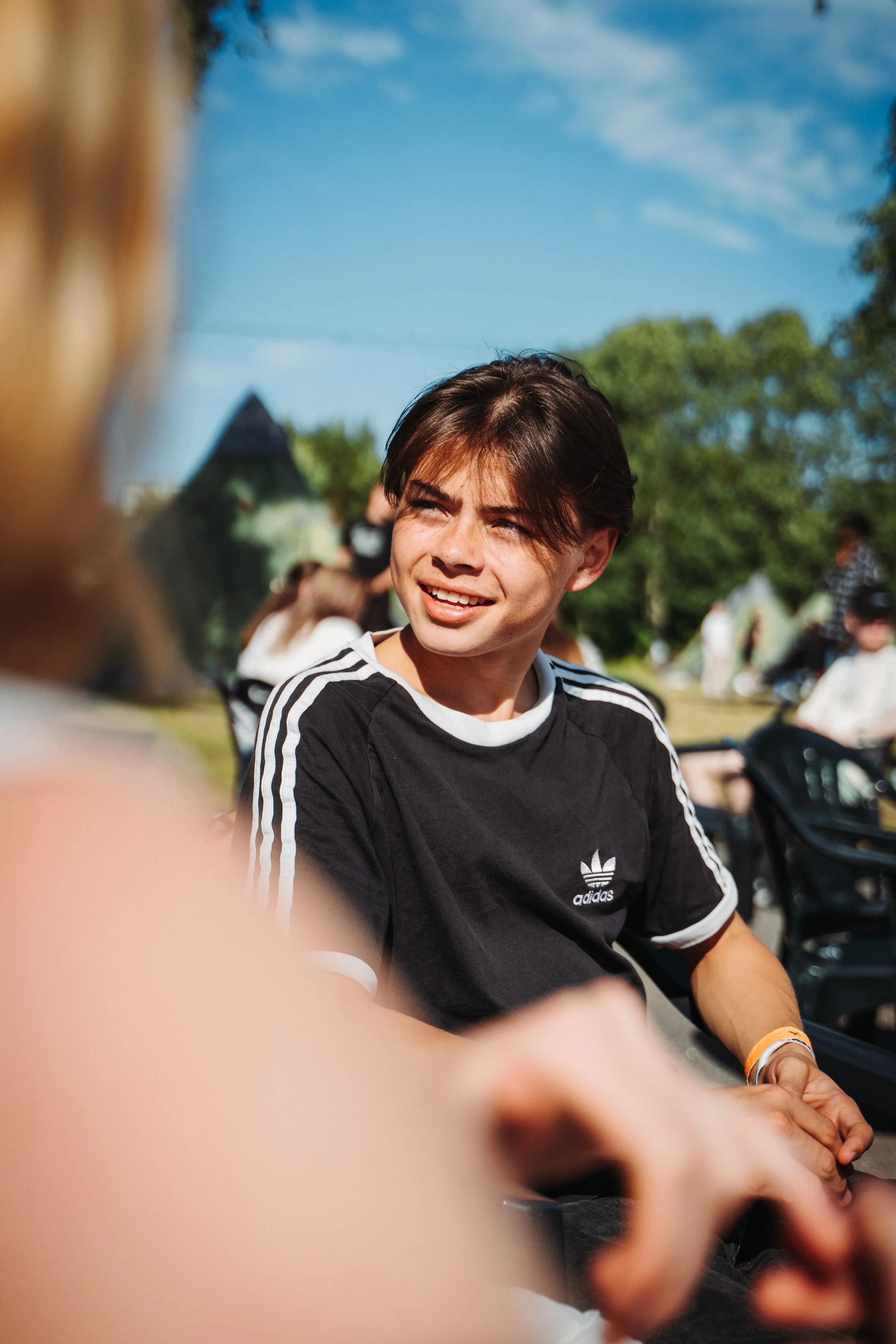 Deltaker sitter i finværet og snakker med en annen deltaker