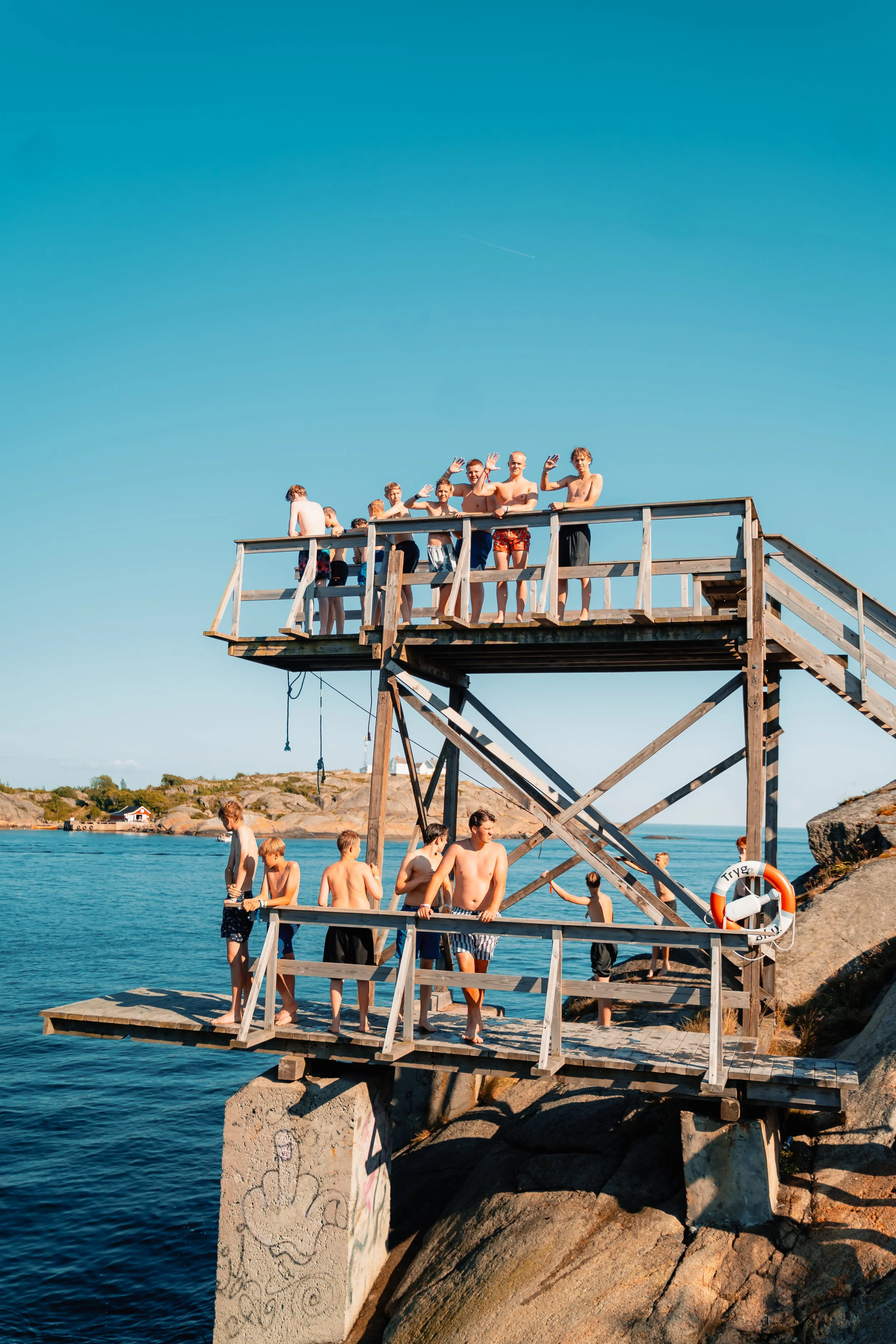 Stupetårn full av badeklare deltakere som smiler og vinker til kamera
