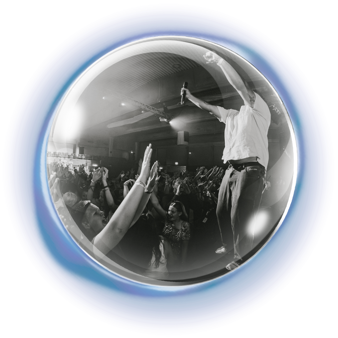 Lovsangsleder på scenen hever hendene sammen med resten av publikum