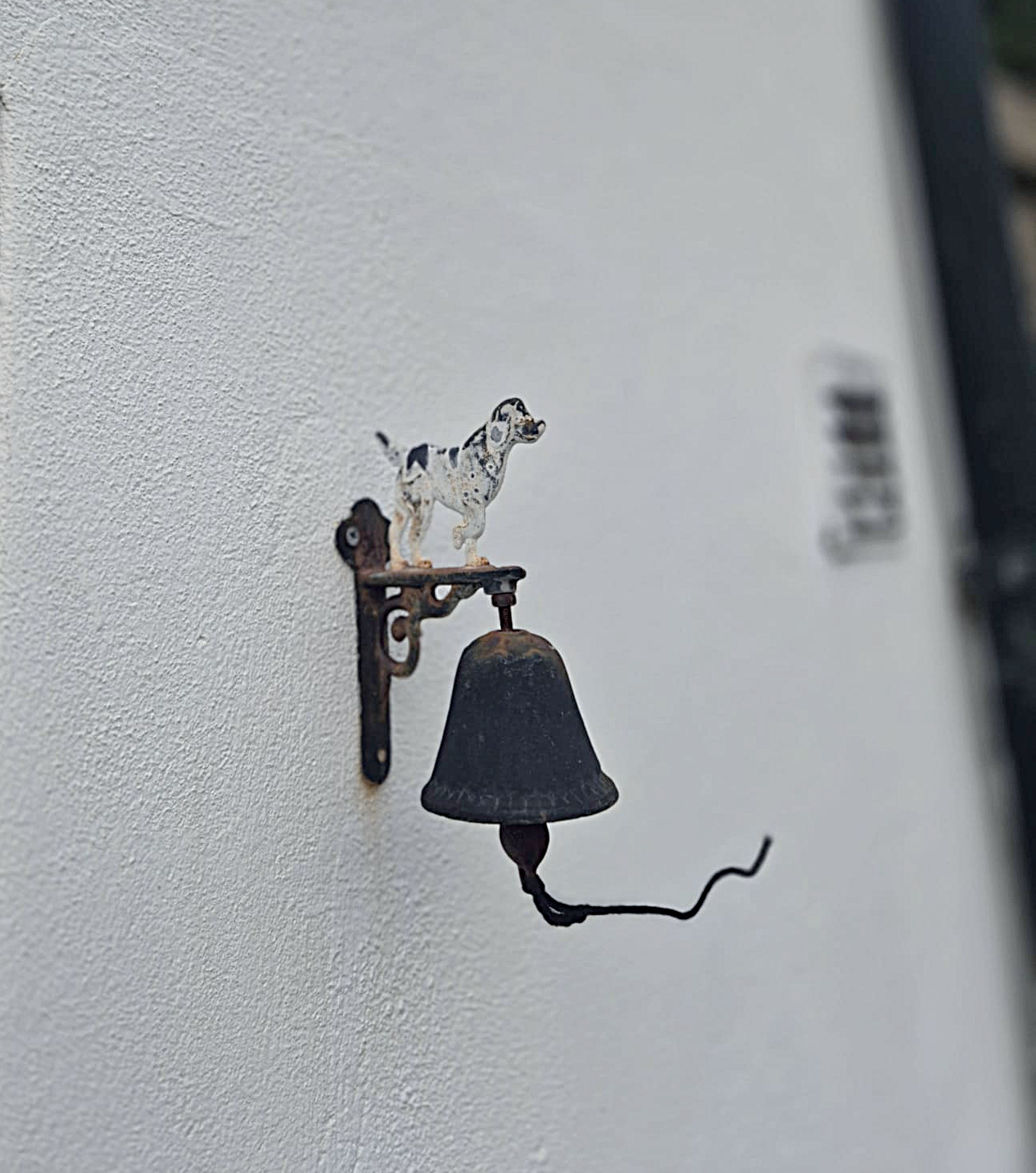 Campainha antiga com um cão de estimação de brinquedo em cima