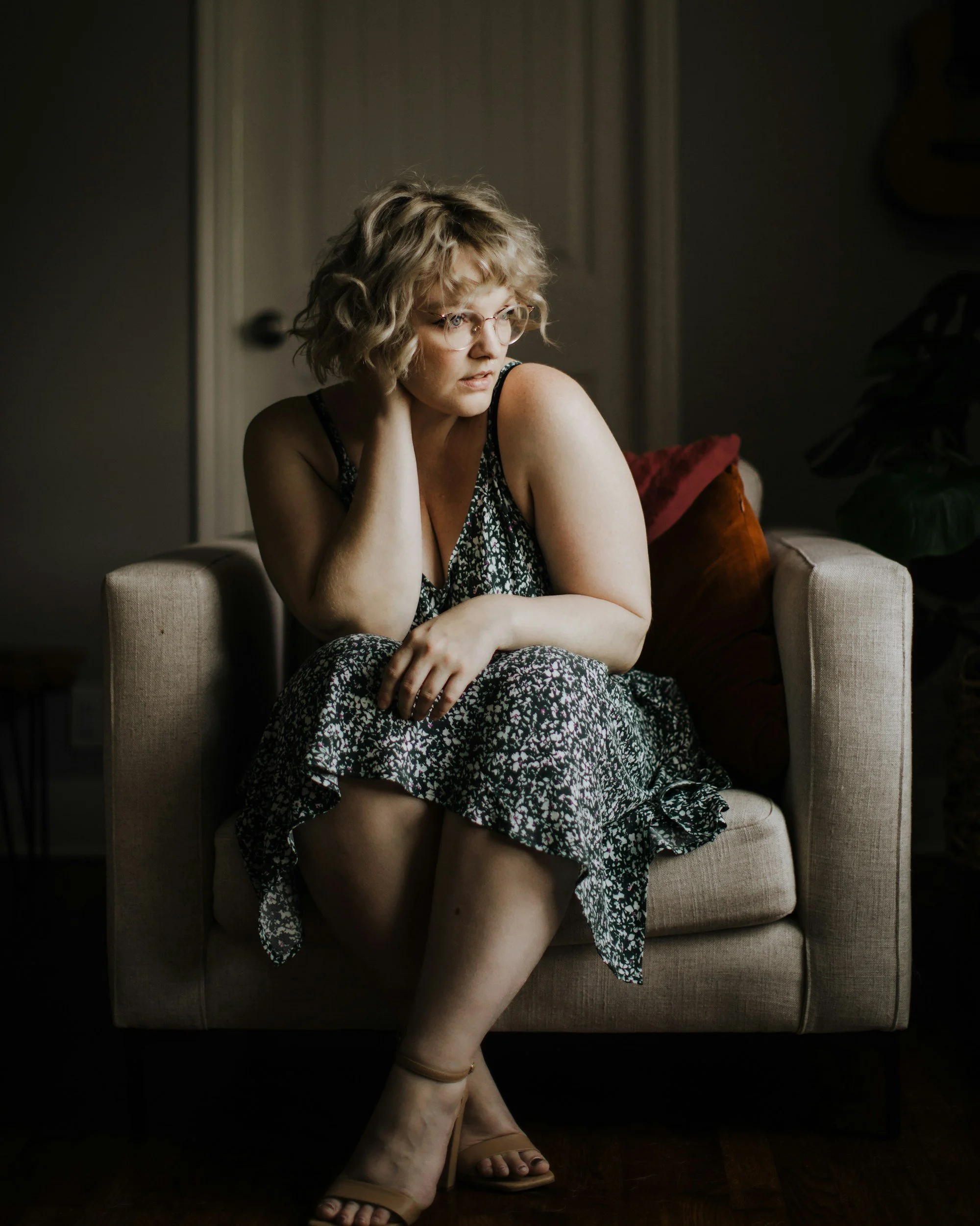 plus size woman in a sundress looking away from camera in a therapists office