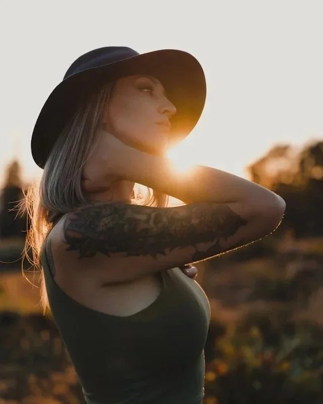 woman in golden hour with tattoos and confident pose