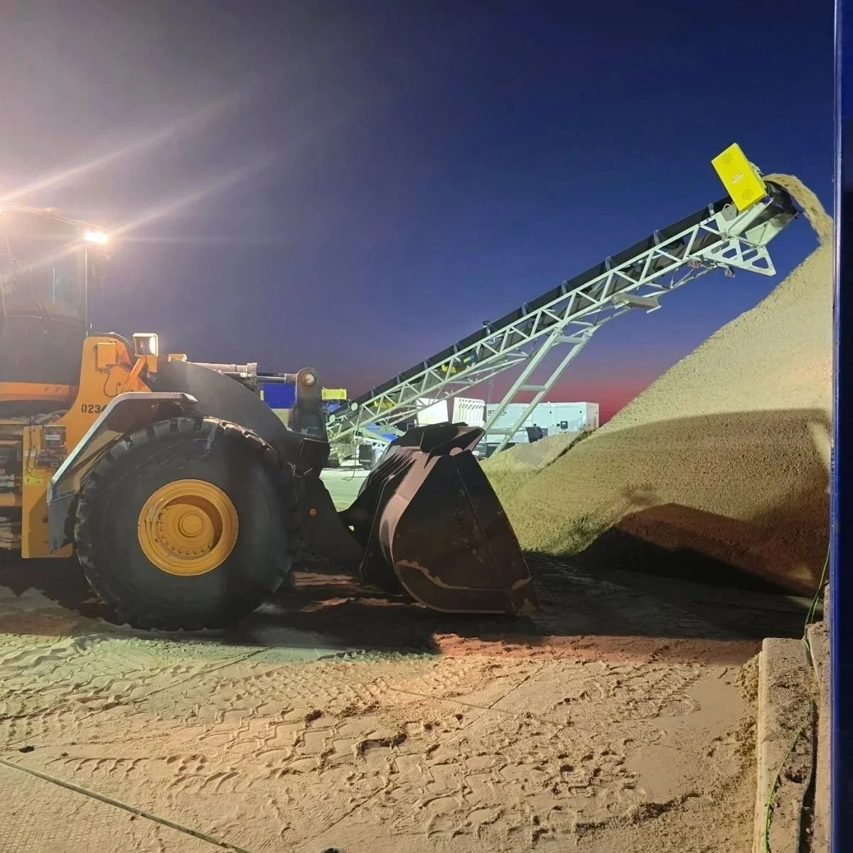 Unloader moving frac sand in the Permian Basin wellsite.