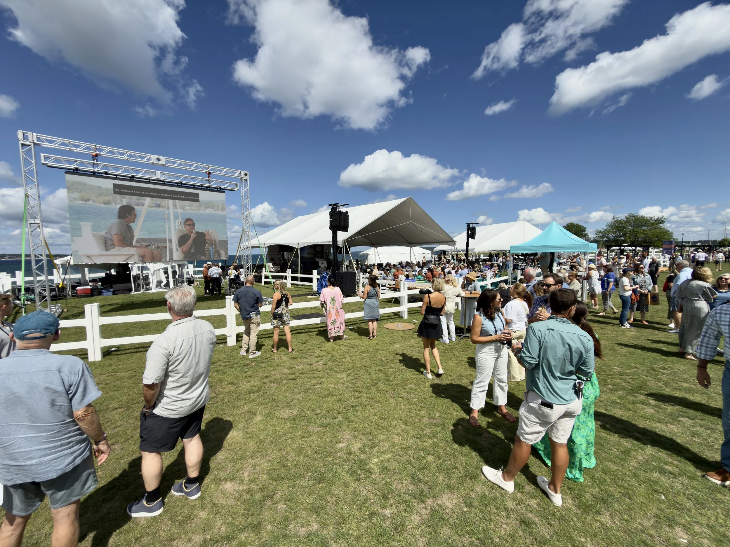 A large outdoor event, Traverse City Food & Wine Festival. Camera recording and projecting cooking demos on LED video walls flown from the truss. Summer event, speakers, and amplifiers to enhance audio throughout the entire downtown.