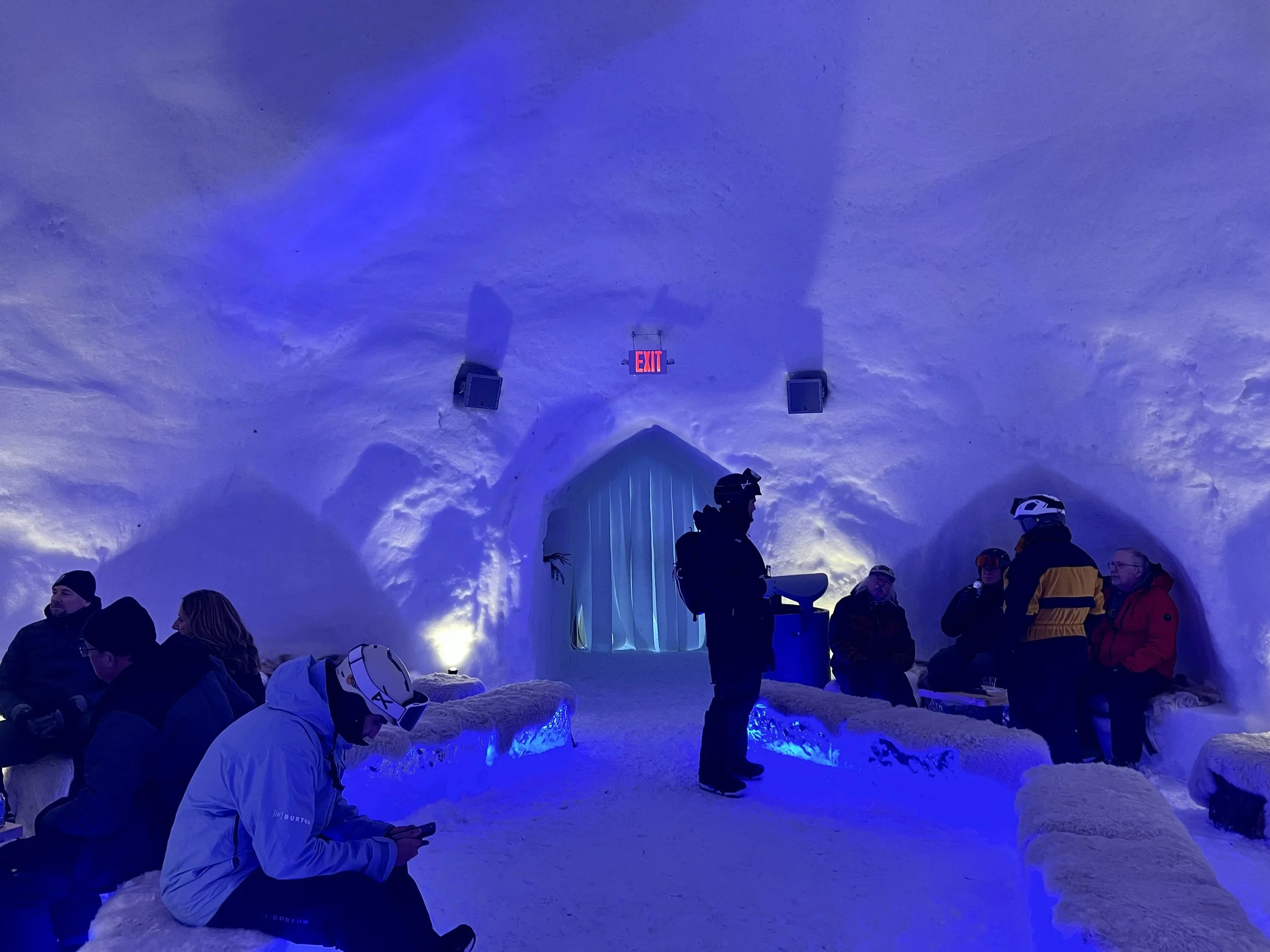 Boyne Iglu winter installation 2026. JBL speakers and crown audio amplifiers to provide sound inside and outside of Iglu. Located at Boyne Mountain, built with snow and ice. Skiers and snowboarders enjoying indoor bar and seating, white wash lights.