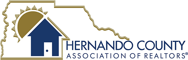Logo for Hernando County Association of Realtors featuring a house with a sun shining behind it.