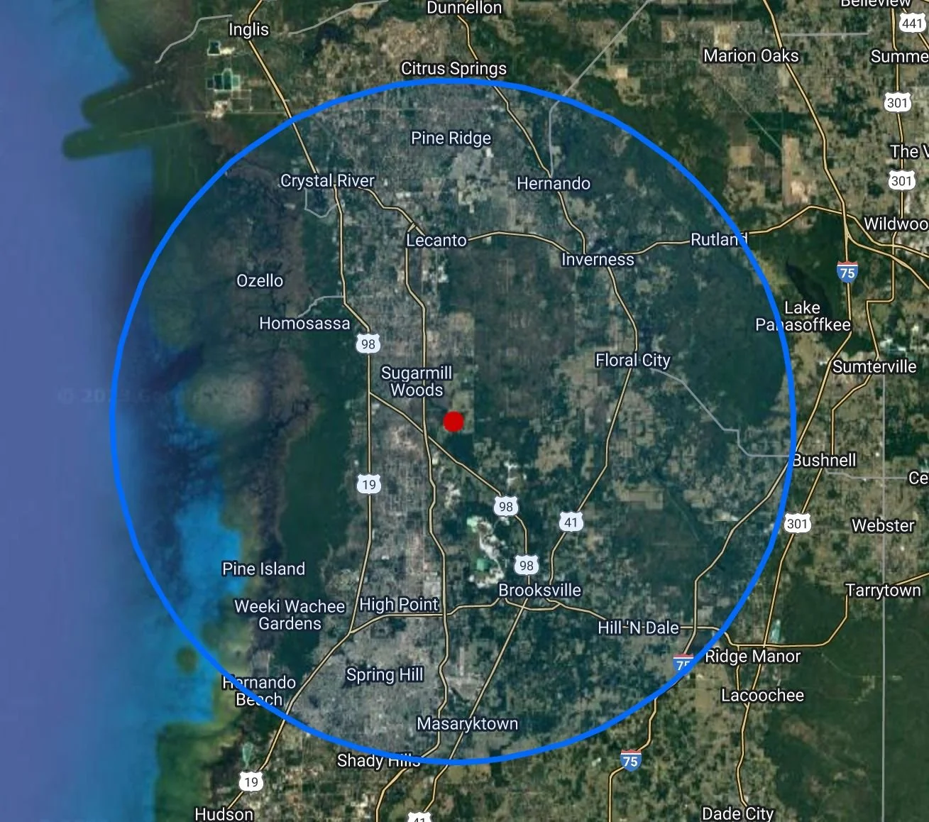 Map of the Florida Gulf Coast showing the area around Hernando, with a red dot indicating a specific location, and a blue circle encompassing surrounding cities, Brooksville, Spring Hill, Hernando Beach, and Weeki Wachee. Sign Post Installation