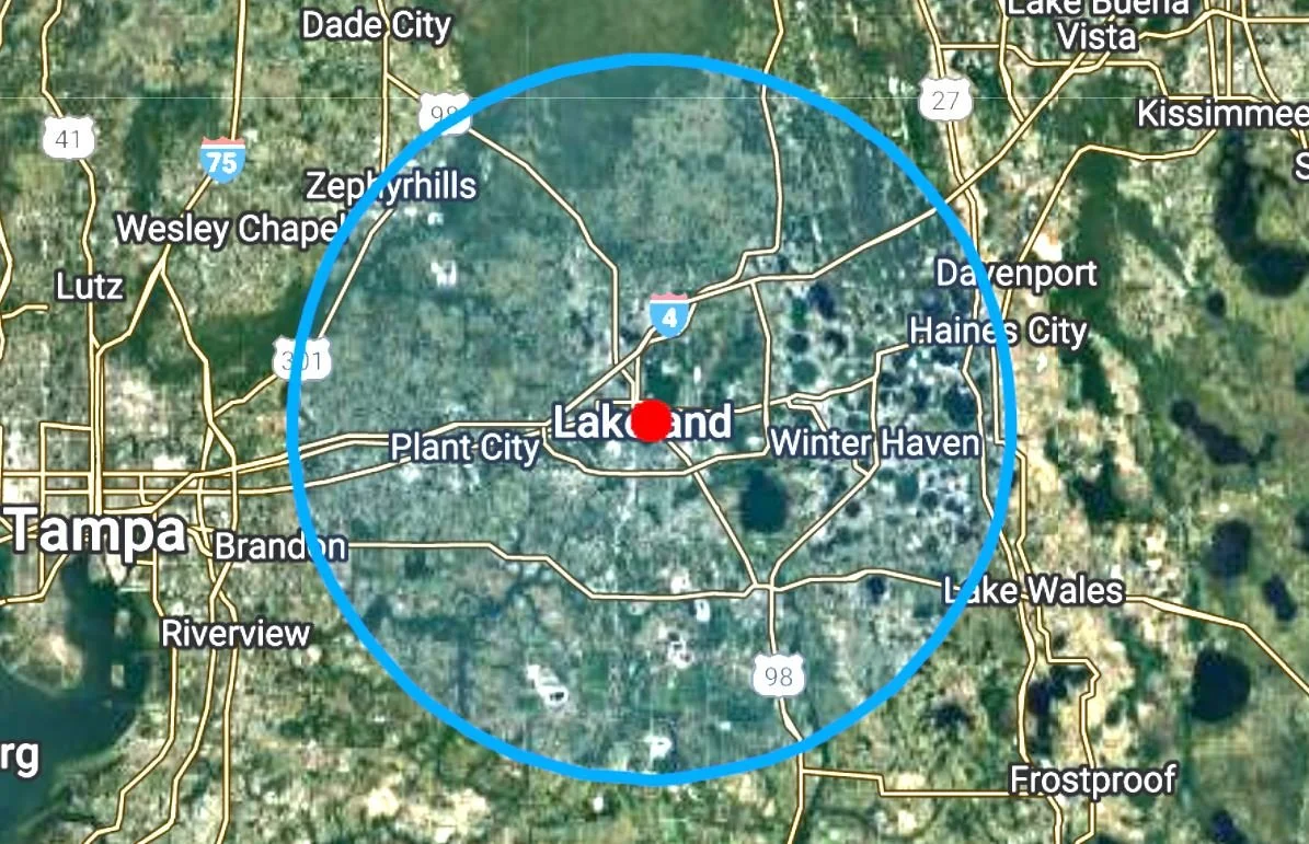 Map of central Florida with Lakeland marked at the center and a blue circle around it. Surrounding cities such as Tampa, Zephyrhills, Dade City, Lake Buena Vista, Kissimmee, Davenport, Haines City, Winter Haven, Lake Wales, Frostproof, Riverview, and Brandon are also visible.