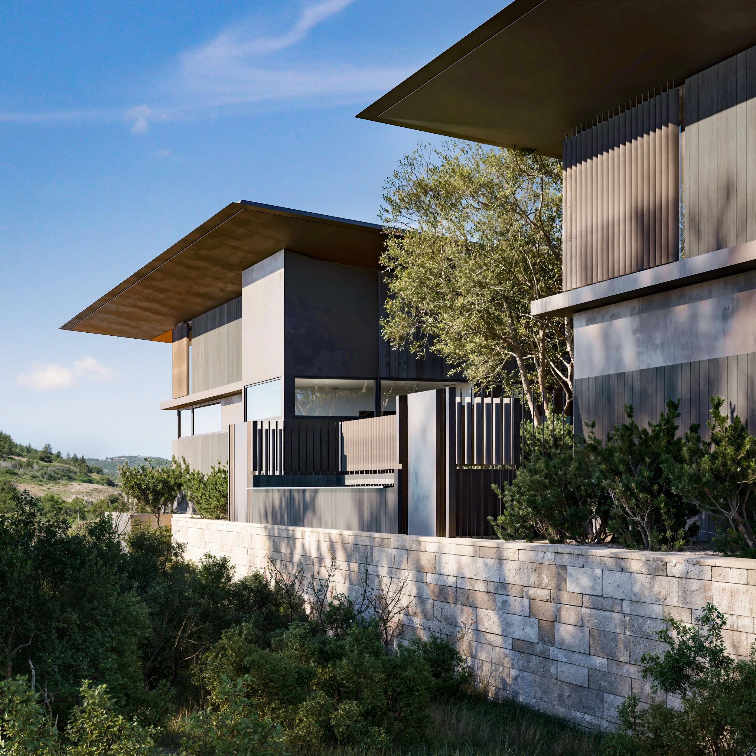 Modern house with angular design, large windows, dark exterior panels, and a stone wall in the foreground, surrounded by greenery under a clear blue sky.