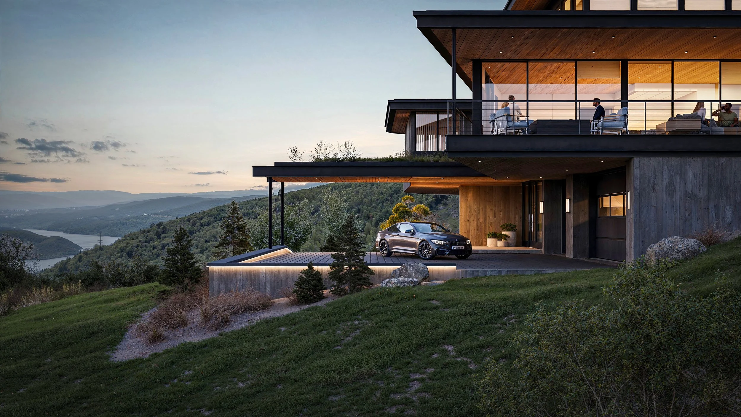 Modern house with large glass windows and wooden accents, situated on a hillside overlooking a river and lush landscape at sunset. A black car is parked in the driveway, and people are sitting and standing on the upper balcony.