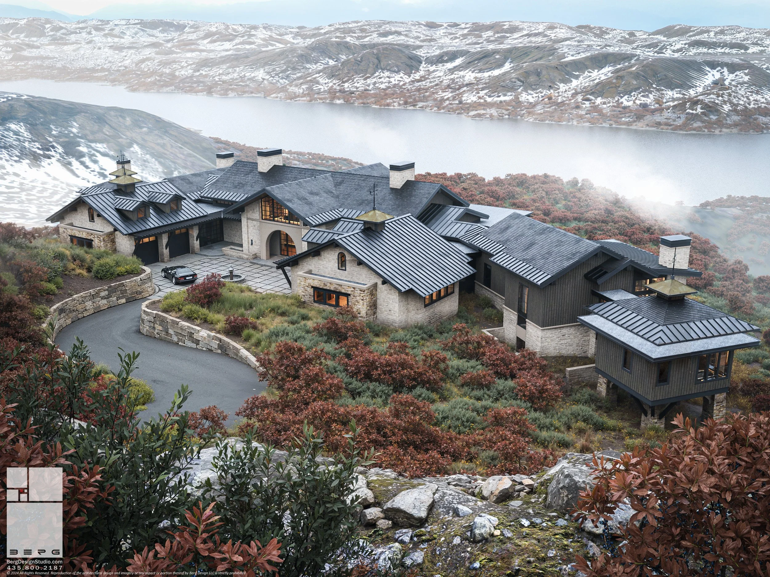 A large house with a black metal roof, stone and wood exterior, situated on a hillside with a winding driveway, overlooking a body of water and mountainous terrain in the background.