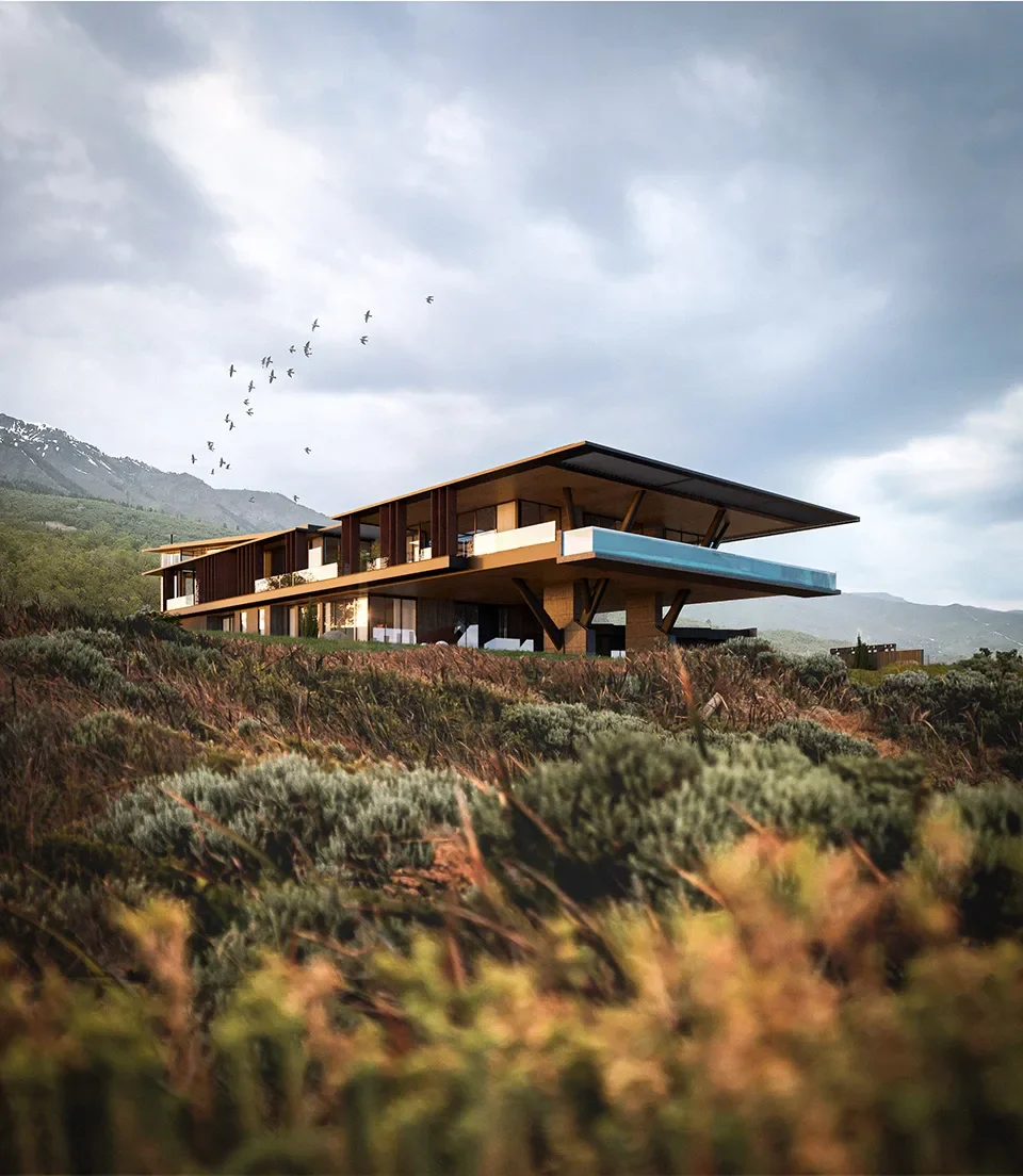 Modern house with large overhanging roof built on a hillside amidst green shrubbery, with mountains and cloudy sky in the background and a flock of birds flying overhead.