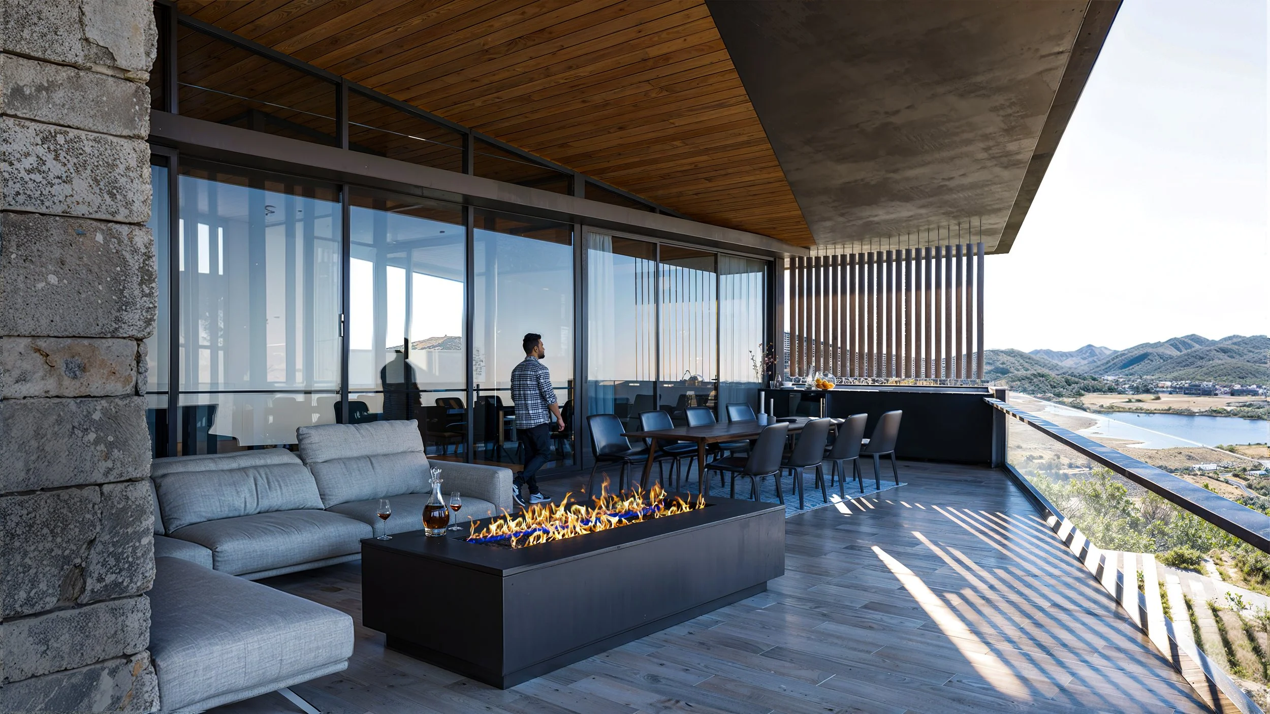 Luxury outdoor balcony with seating area, fireplace, and scenic mountain and river view