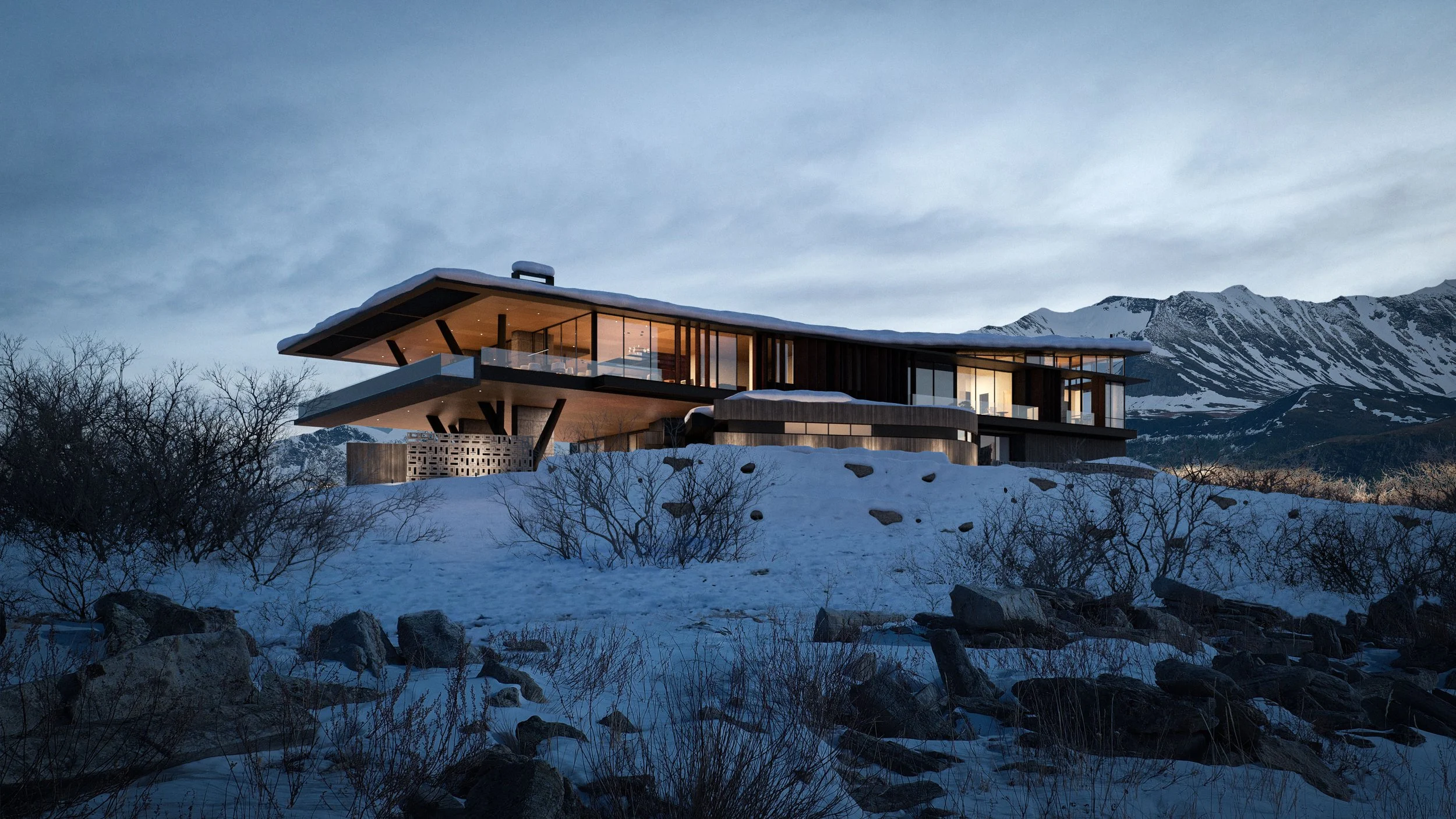 Modern house with large glass windows, situated on snowy terrain with mountain backdrop at dusk.