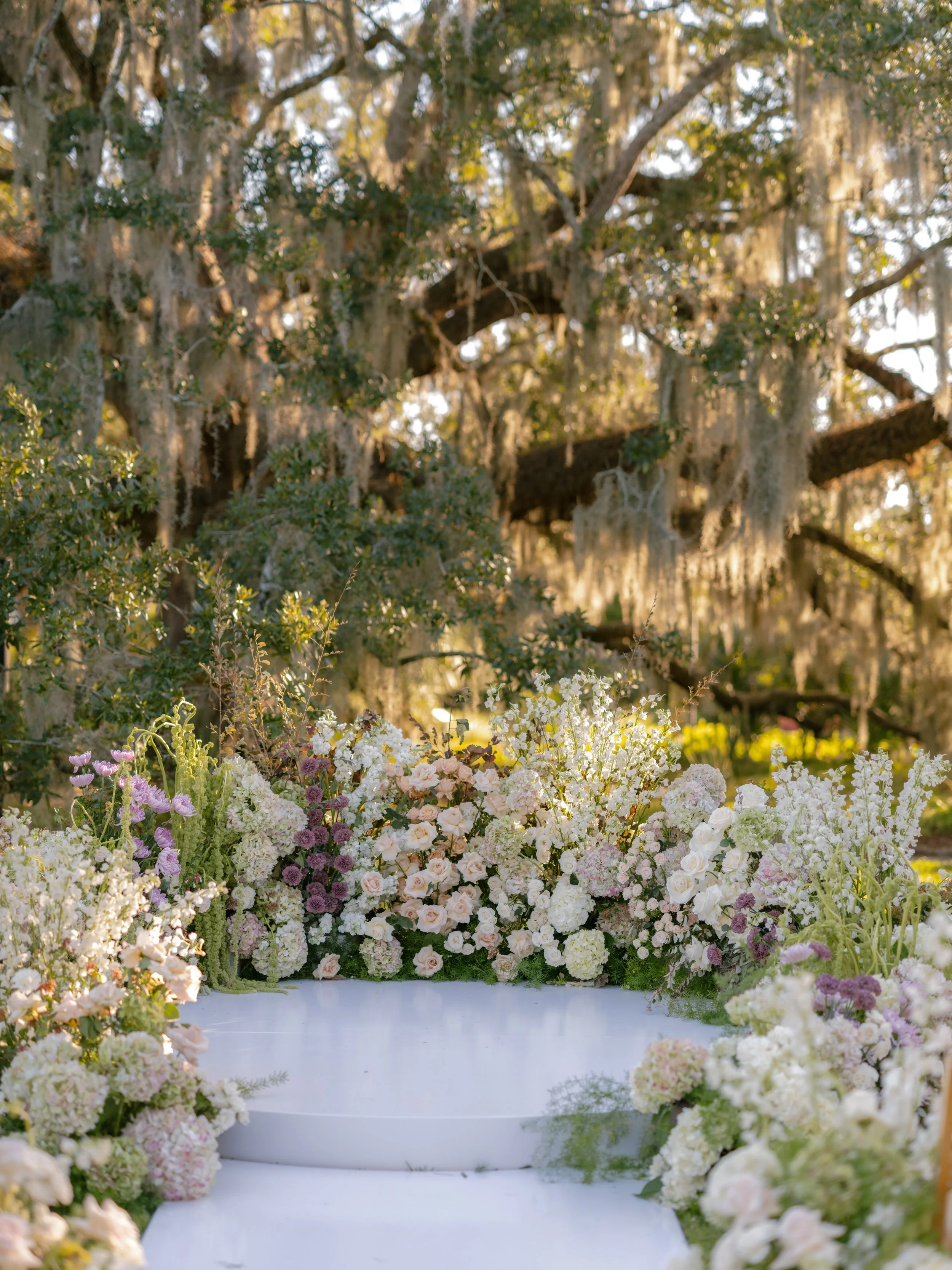 Large lush ceremony floral installation creating a fully immersive stage under the Spanish mossy oak trees at City Park in New Orleans..