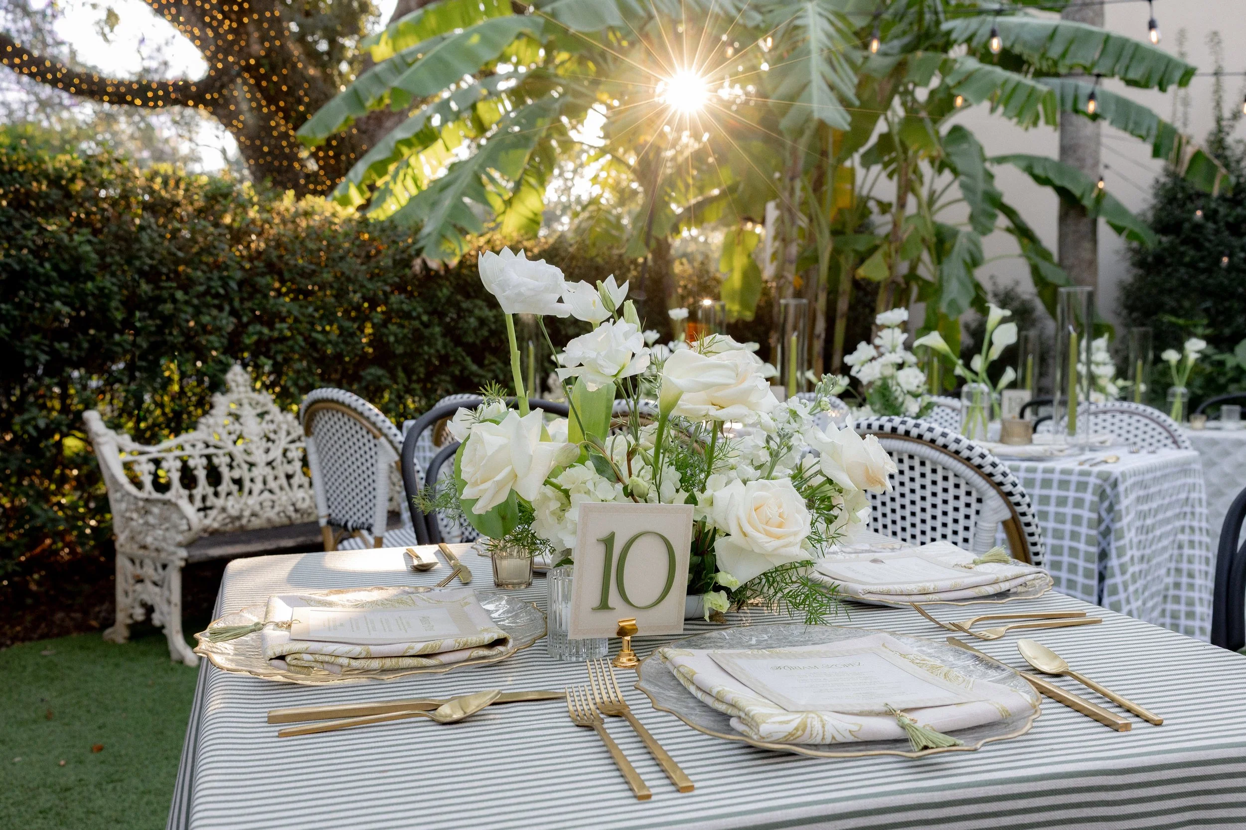 Large classic white floral centerpiece tablescape at a sunset wedding at The Columns Hotel on St. Charles Ave. New Orleans.