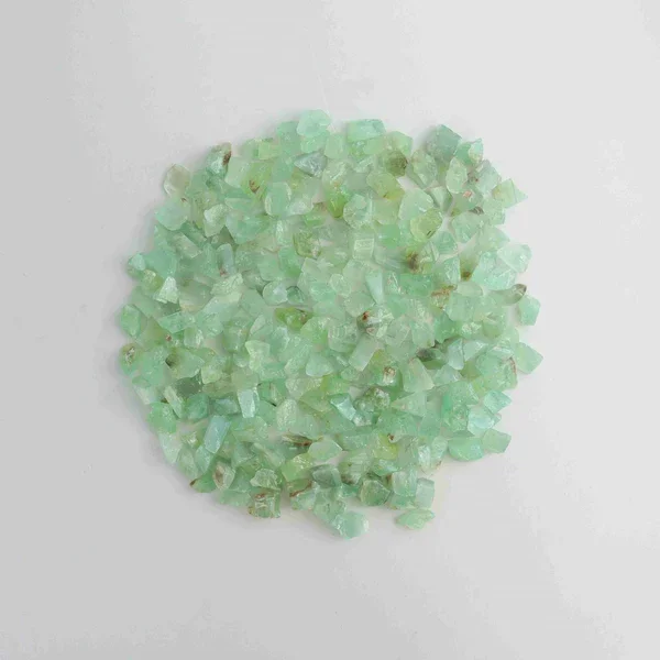 A collection of small, irregularly shaped green stones on a white background.
