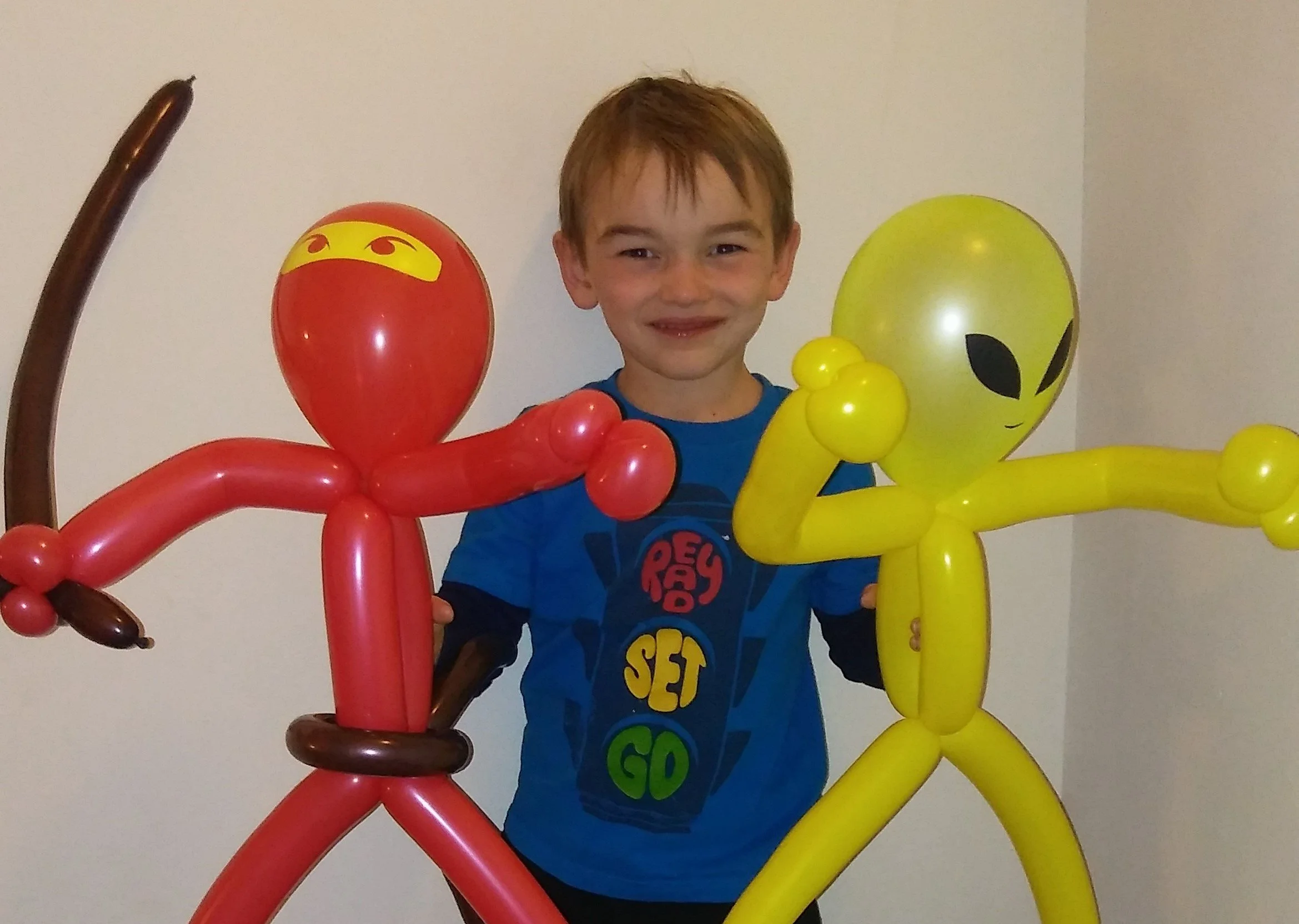 Child holding a ninja and alien balloon twisted creations