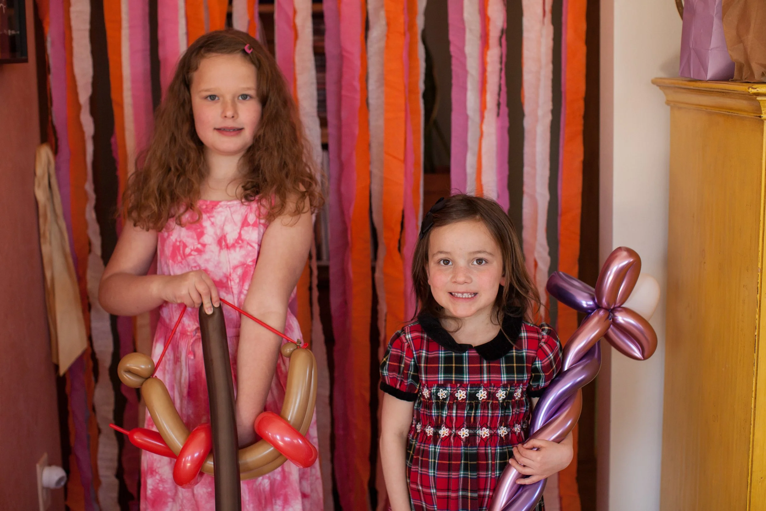 Kids at Birthday party with balloons twisted into bow and arrow and wand