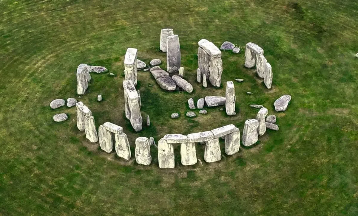 Aerial view of Stonehenge, a prehistoric monument with large standing stones arranged in a circular formation on a grassy field.