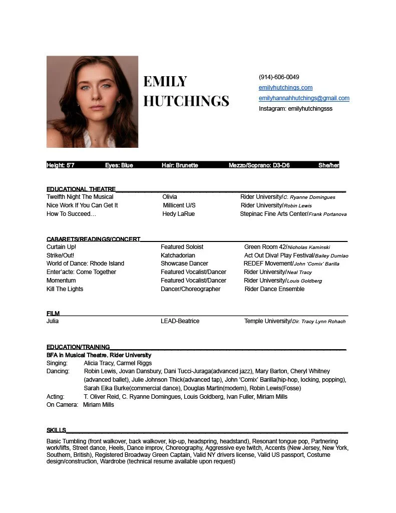 A headshot of a young woman with brown hair and blue eyes. She is looking at the camera with a neutral expression, and wearing a sleeveless top.