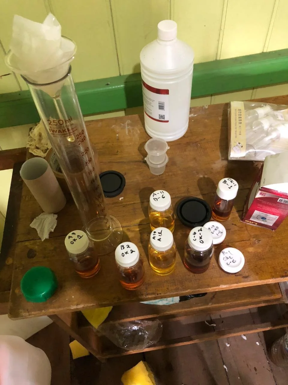 Botol sampel kontrol kualitas minyak nilam murni RUMEVA dengan label batch produksi.