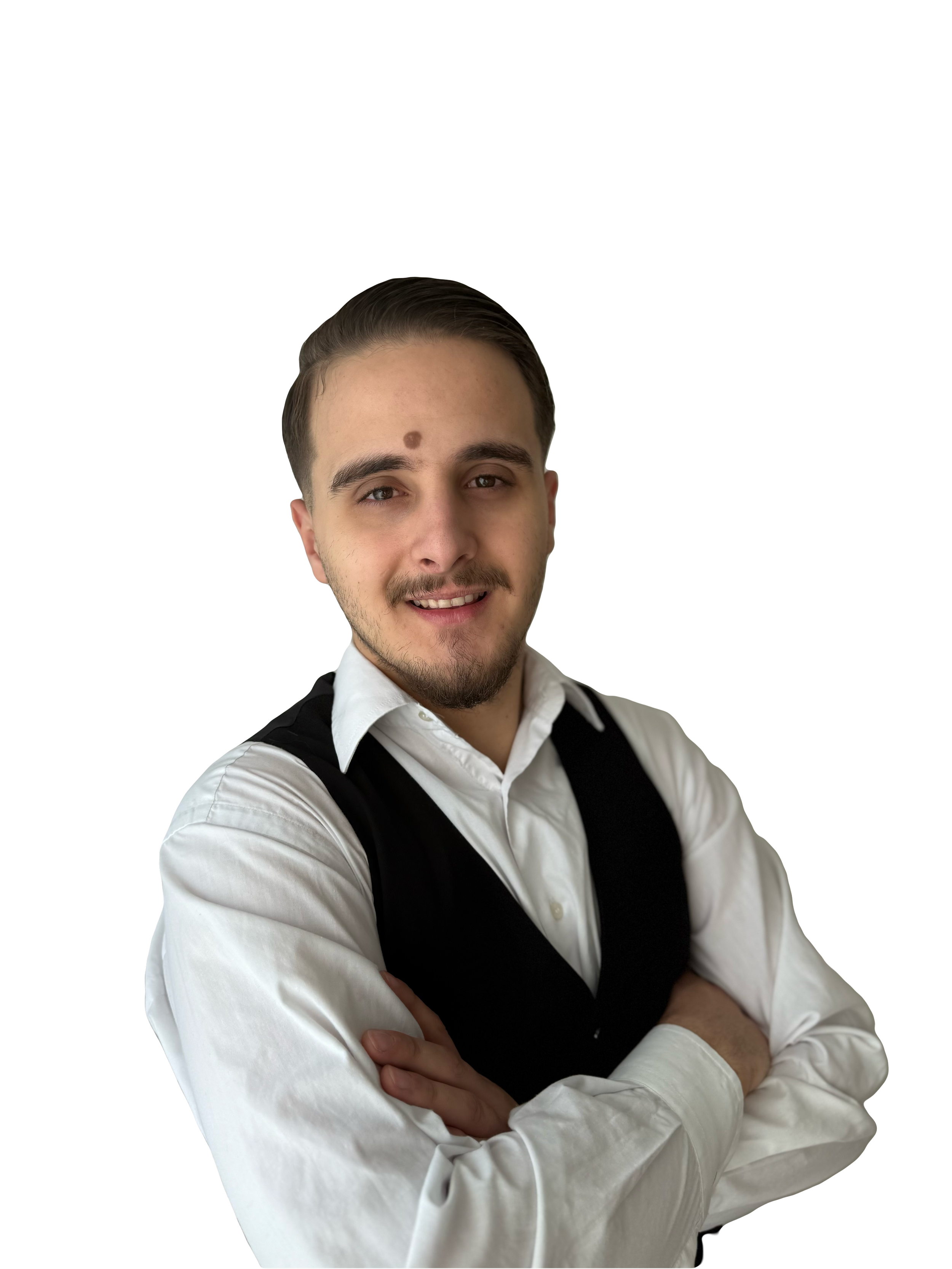 Junger Mann mit dunklem Haar, hellbraunen Augen, Bart und Bartstopp, trägt weiße Hemd mit schwarzer Weste, lächelt, steht vor schwarzem Hintergrund.