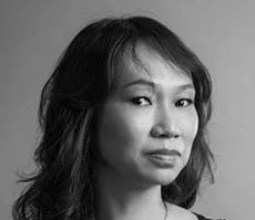 Black and white portrait of a woman with shoulder-length hair, looking at the camera with a neutral expression.