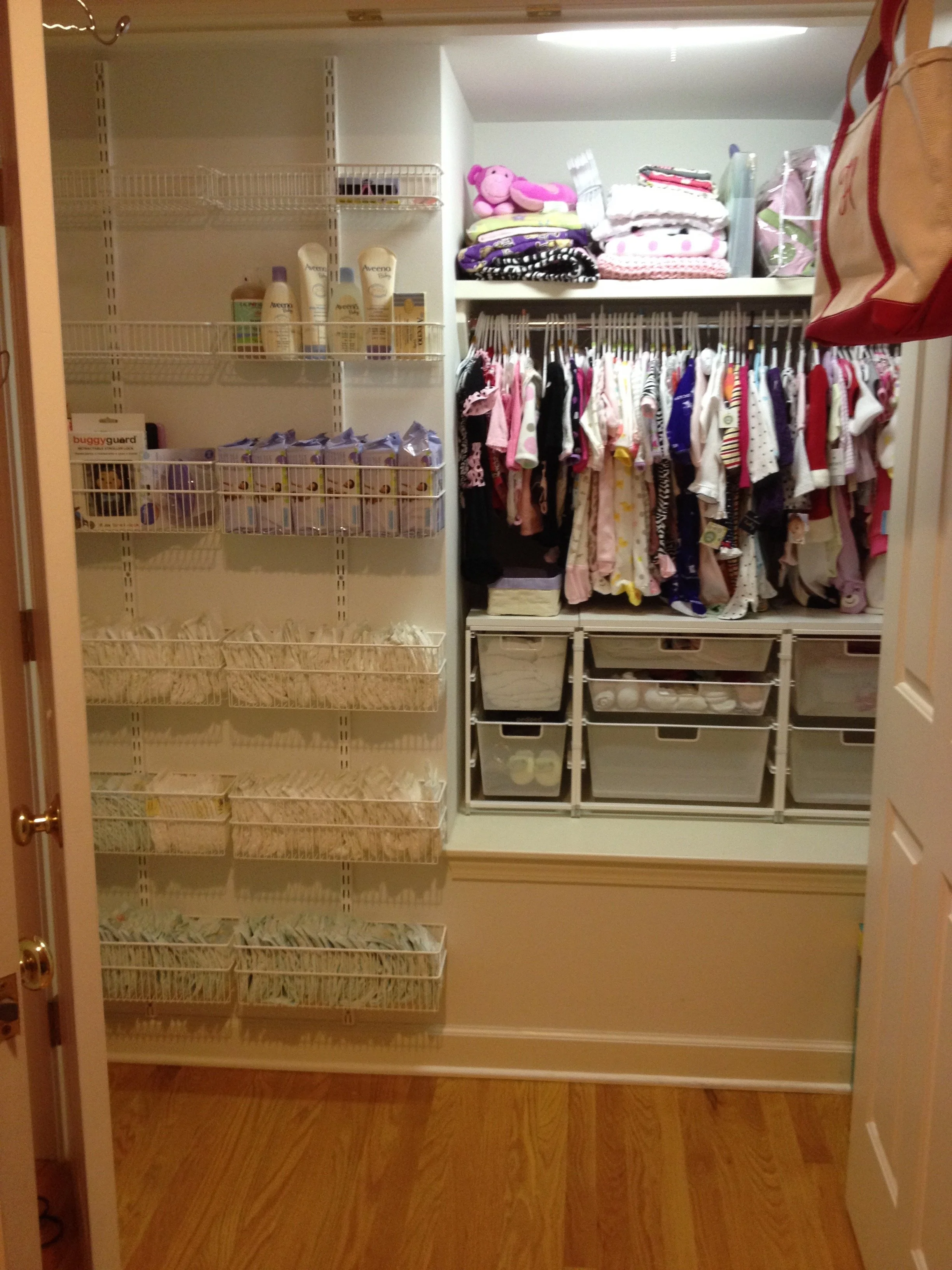 A walk-in closet with organized shelves of baby products, clothes, and storage bins.