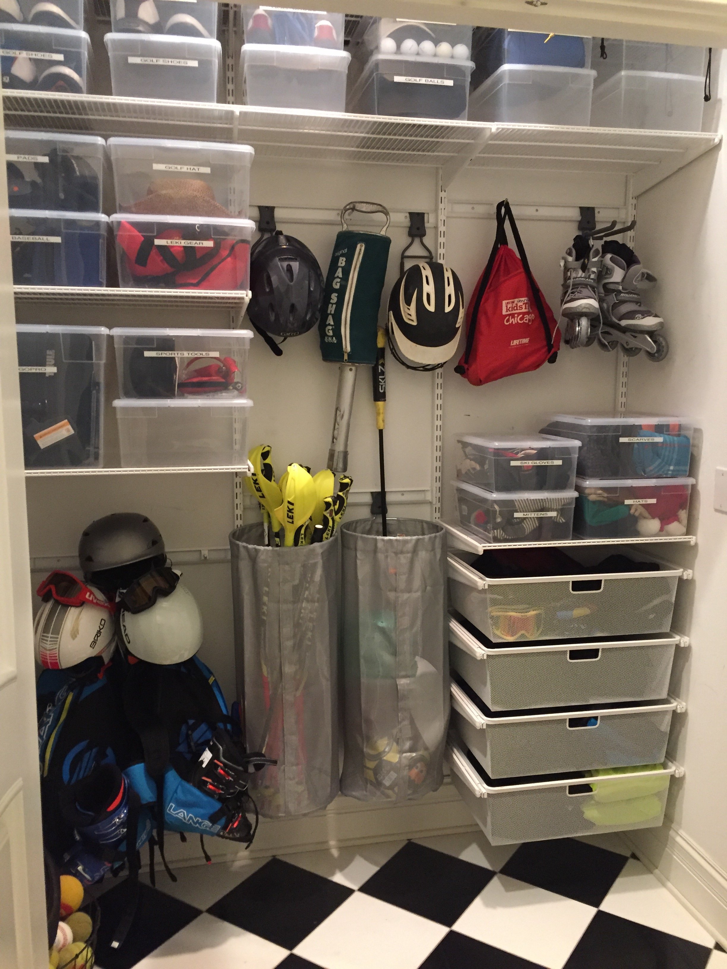 A closet organized with sports gear, including helmets, golf clubs, golf balls, golf hats, gloves, ice skates, rollerblades, and various storage boxes for accessories and tools.