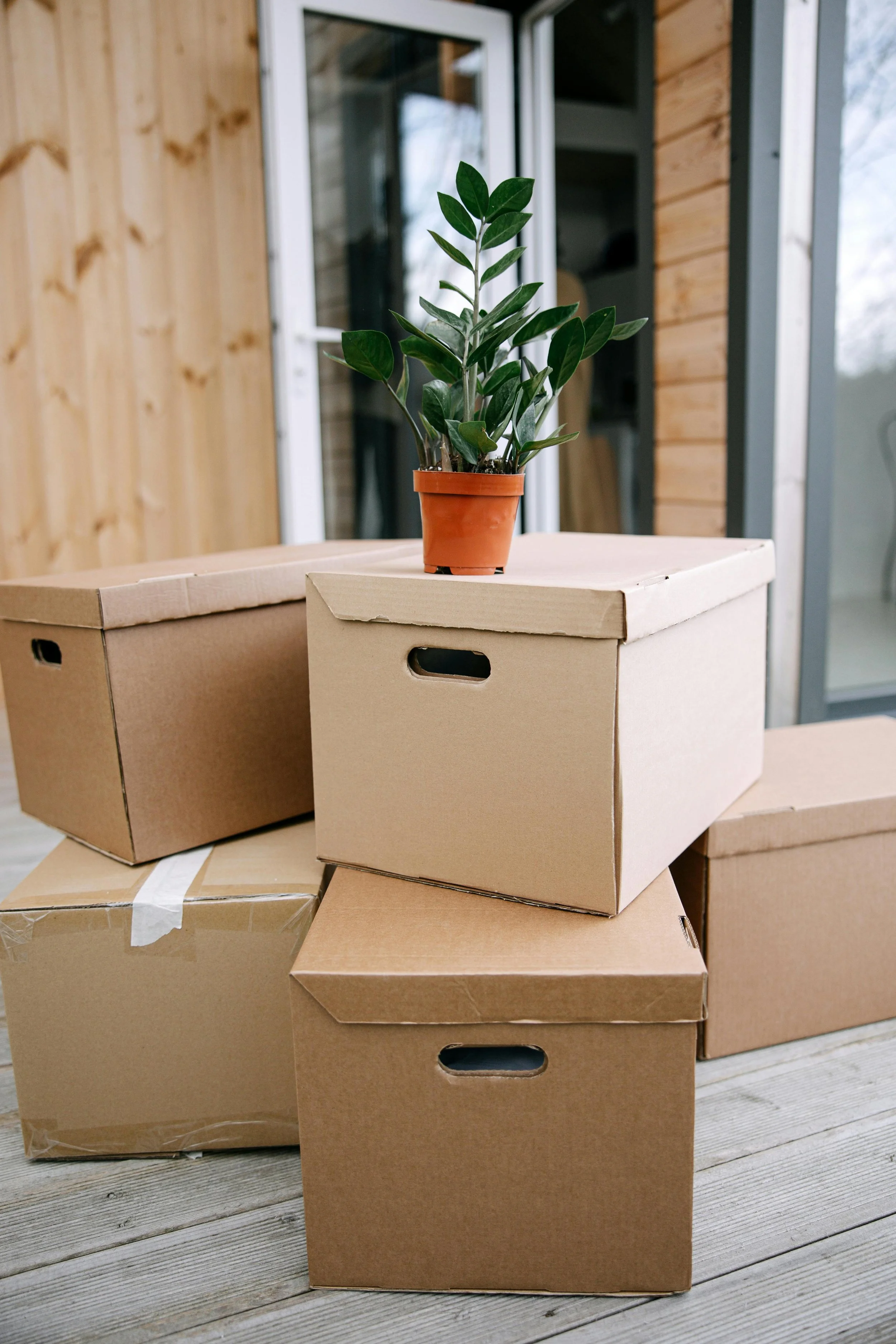 Packed moving boxes outside a home, symbolizing professional moving and organization services in Rochester, MN