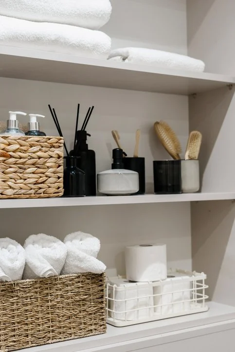 Organized bathroom shelves with baskets, towels, and storage solutions in a Rochester, MN home